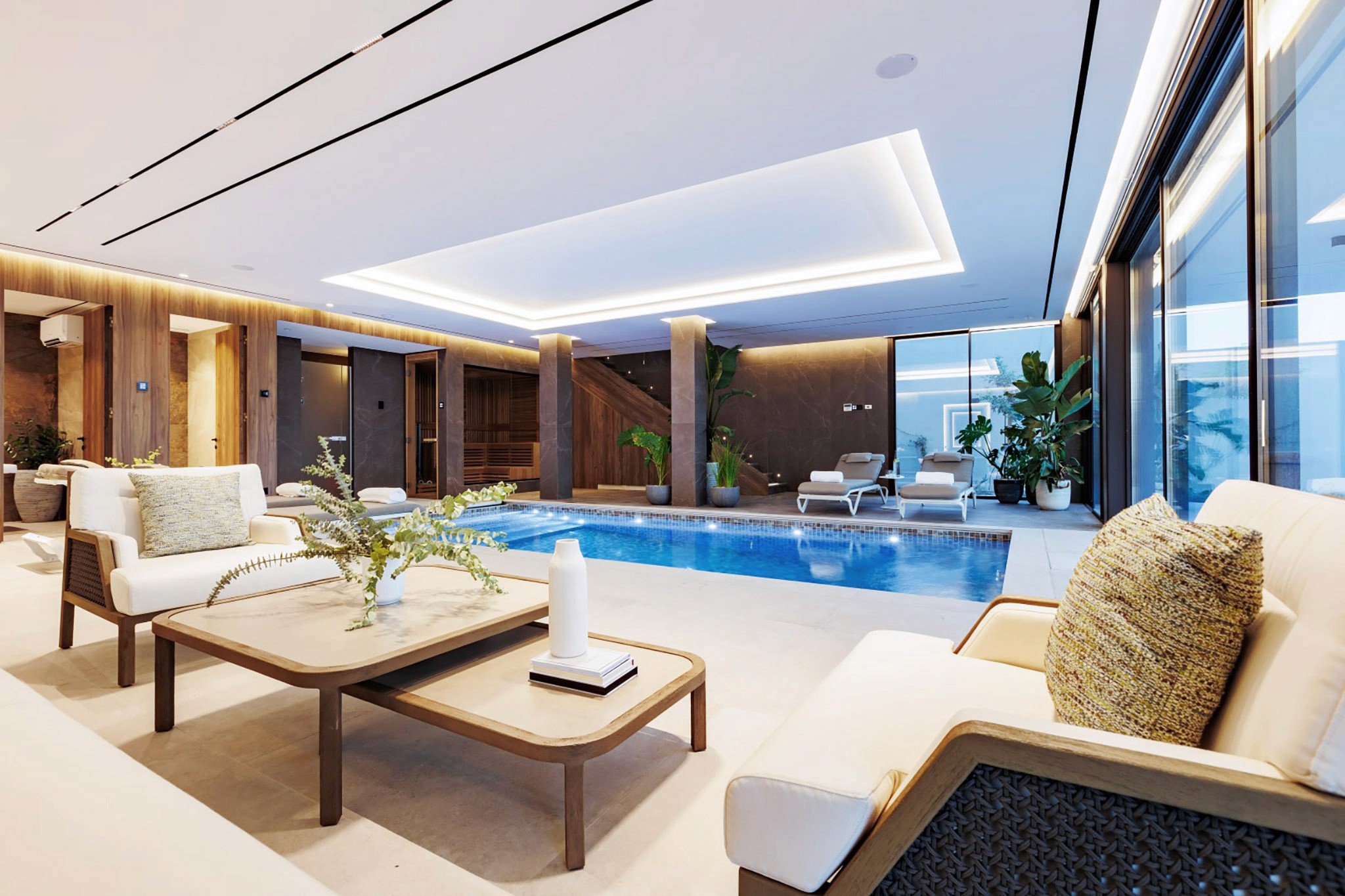 Villa Trio indoor-outdoor courtyard with central pool, lounge seating, and warm wood-panelled walls