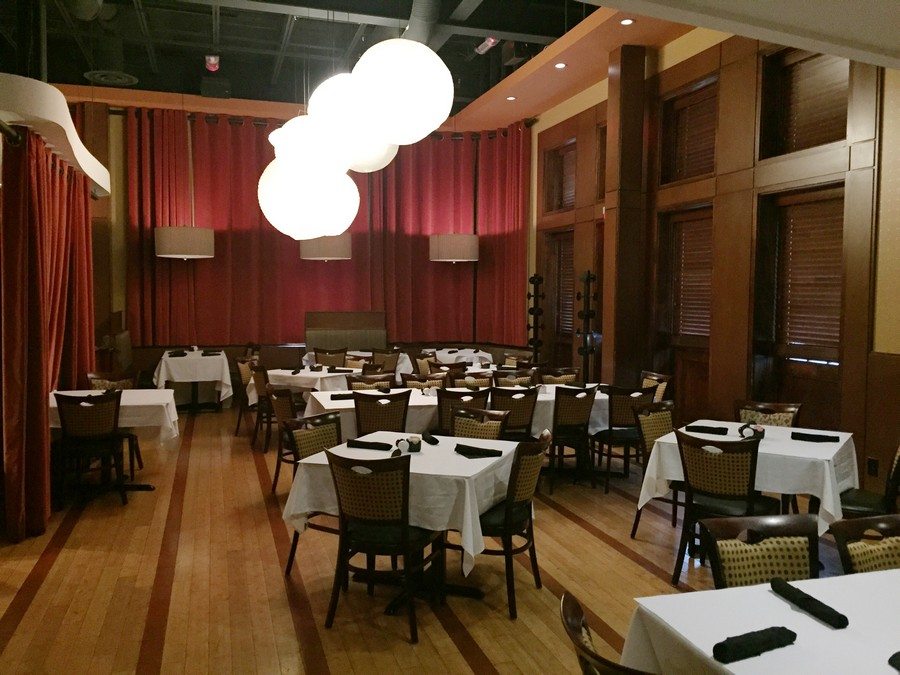 Pineapple Room at J. Liu Worthington with white-clothed tables, red curtains and globe lights