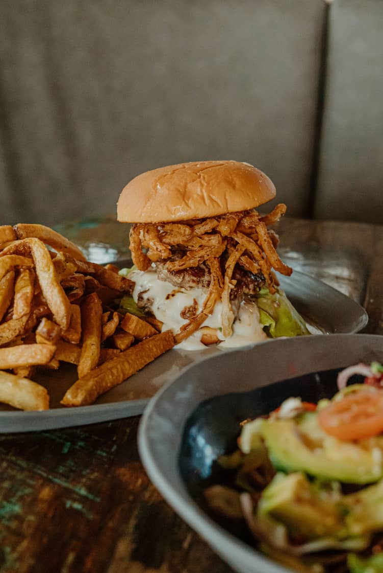 All dressed burger on a plate with french fries