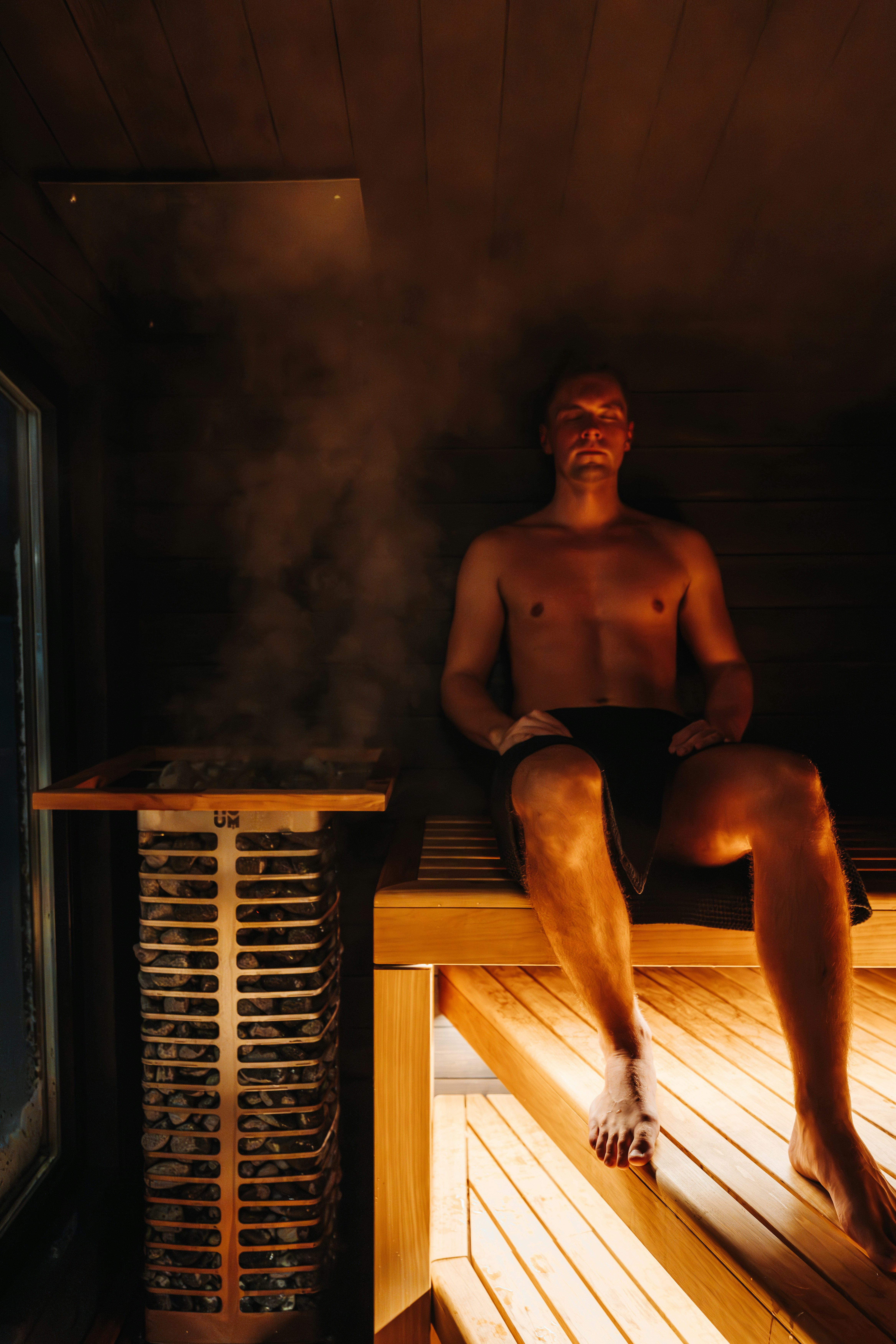 A man is relaxing in a steamy sauna.