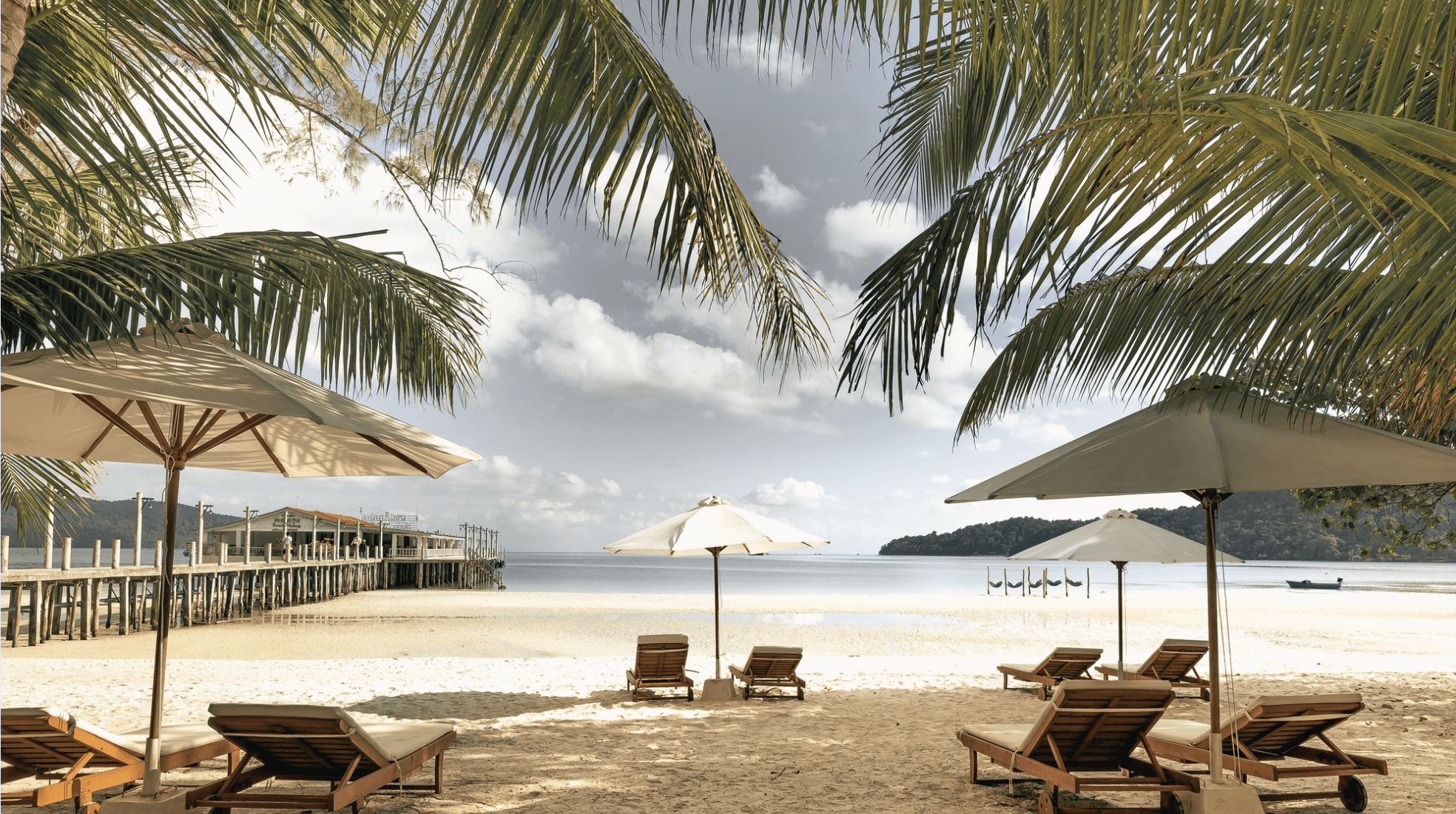 a woman sitting on a beach reading a book