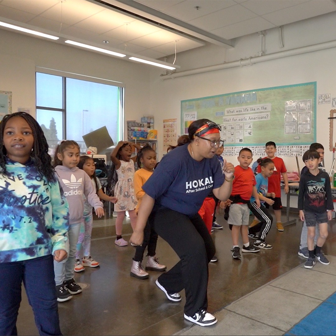 Elementary school students participating in a dance and movement activity during an after-school enrichment program