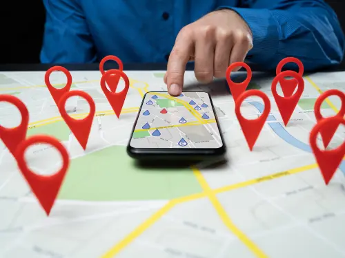 Man searching maps app on smartphone on top of real map