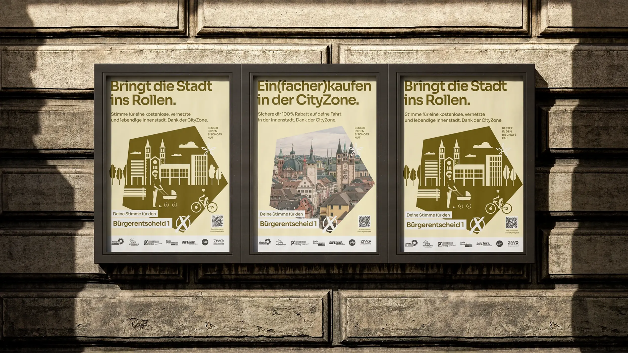 Drei Plakate „Bringt die Stadt ins Rollen“ und „Ein(facher)kaufen in der CityZone“ an einer Steinwand.