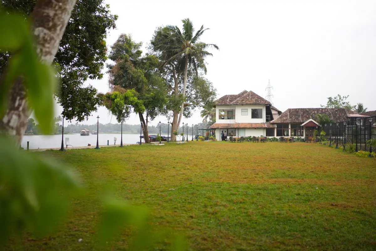 Lakeside lawn at Vedic Village Alleppey with a heritage building, ideal for pre-wedding gatherings such as mehendi or haldi