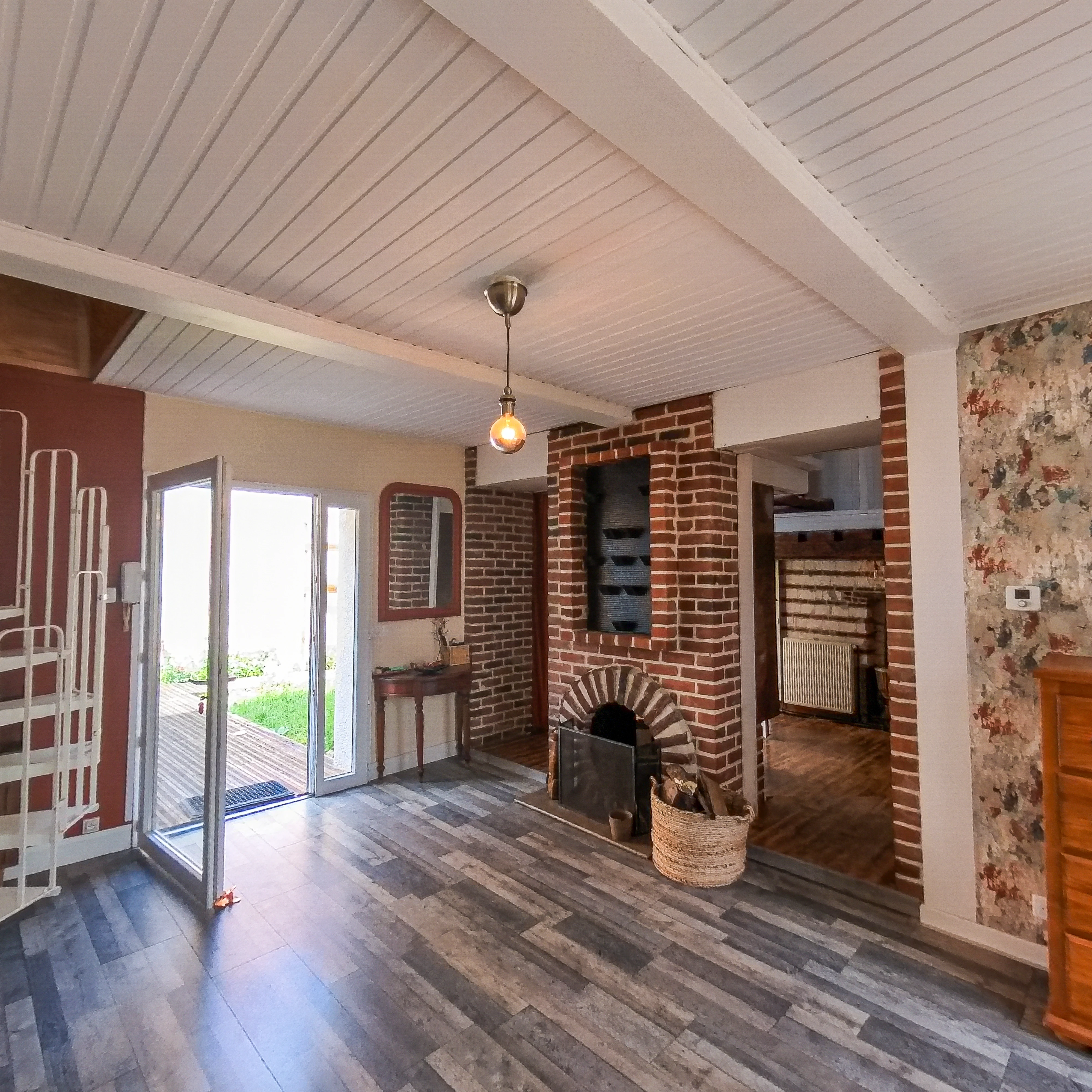 Warm wood kitchen with open shelves, spice jars, countertop decor, and a bowl of fruit.