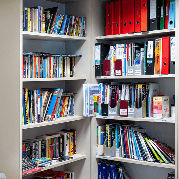 Shelf packed with books of various subjects and colors, meticulously organized