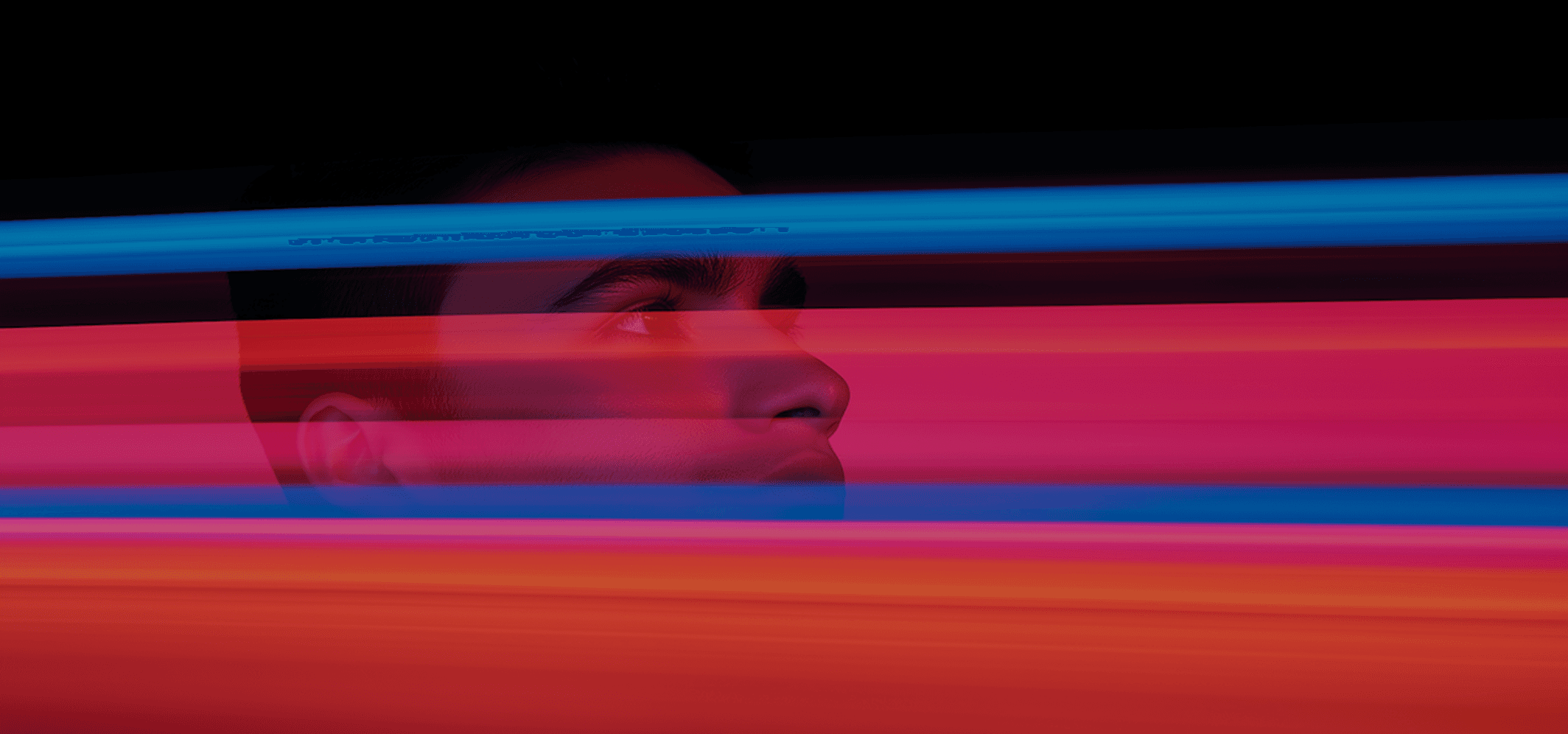 In the foreground, a man is positioned, looking directly at the viewer with a soft-focus background behind him.