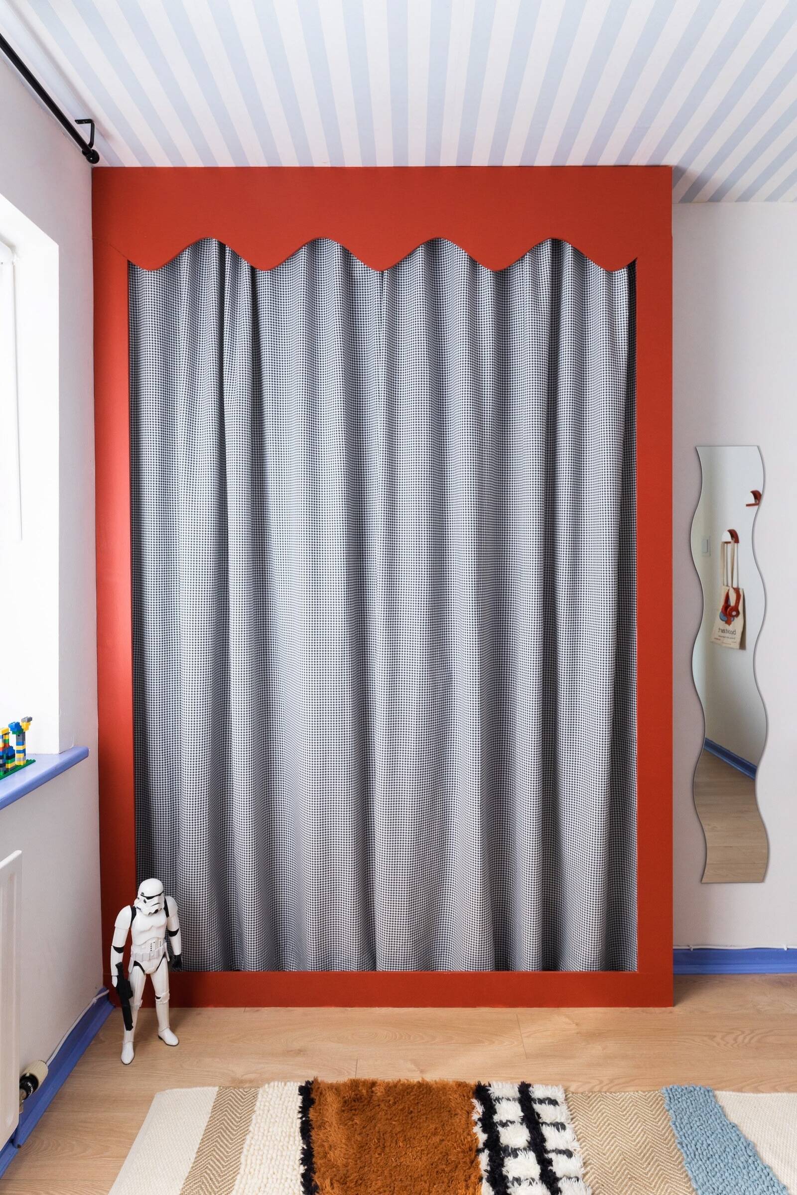 Bespoke wardrobe with material curtain, surrounded by details and toys in a contemporary room renovation by interior design studio Atelier Akuko.