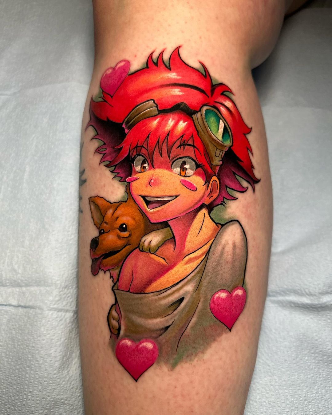 This tattoo features a cheerful character with vibrant red hair and goggles, joyfully holding a small dog, capturing a fun and playful spirit.