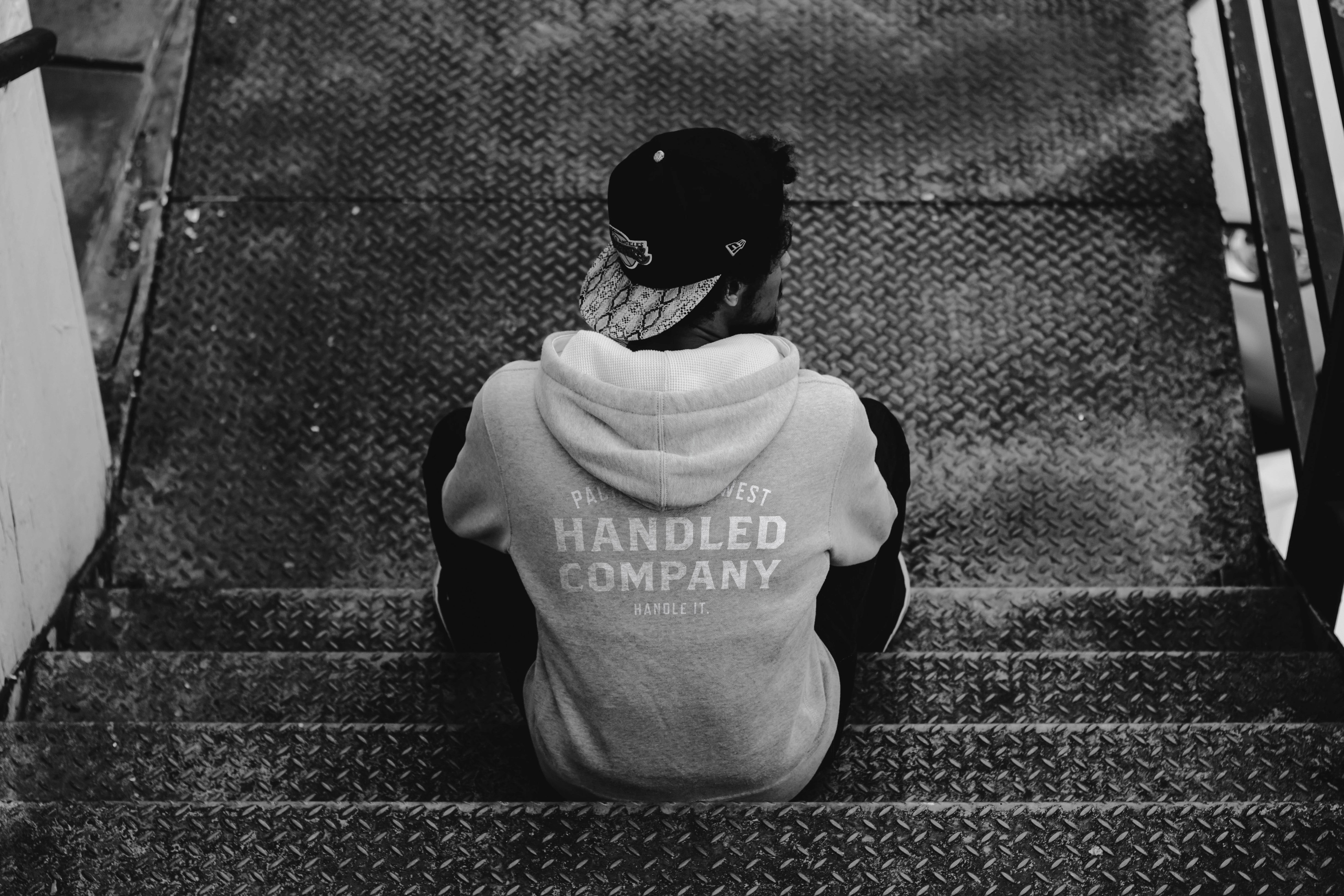 Athlete sitting on gym floor wearing Handled Company hoodie