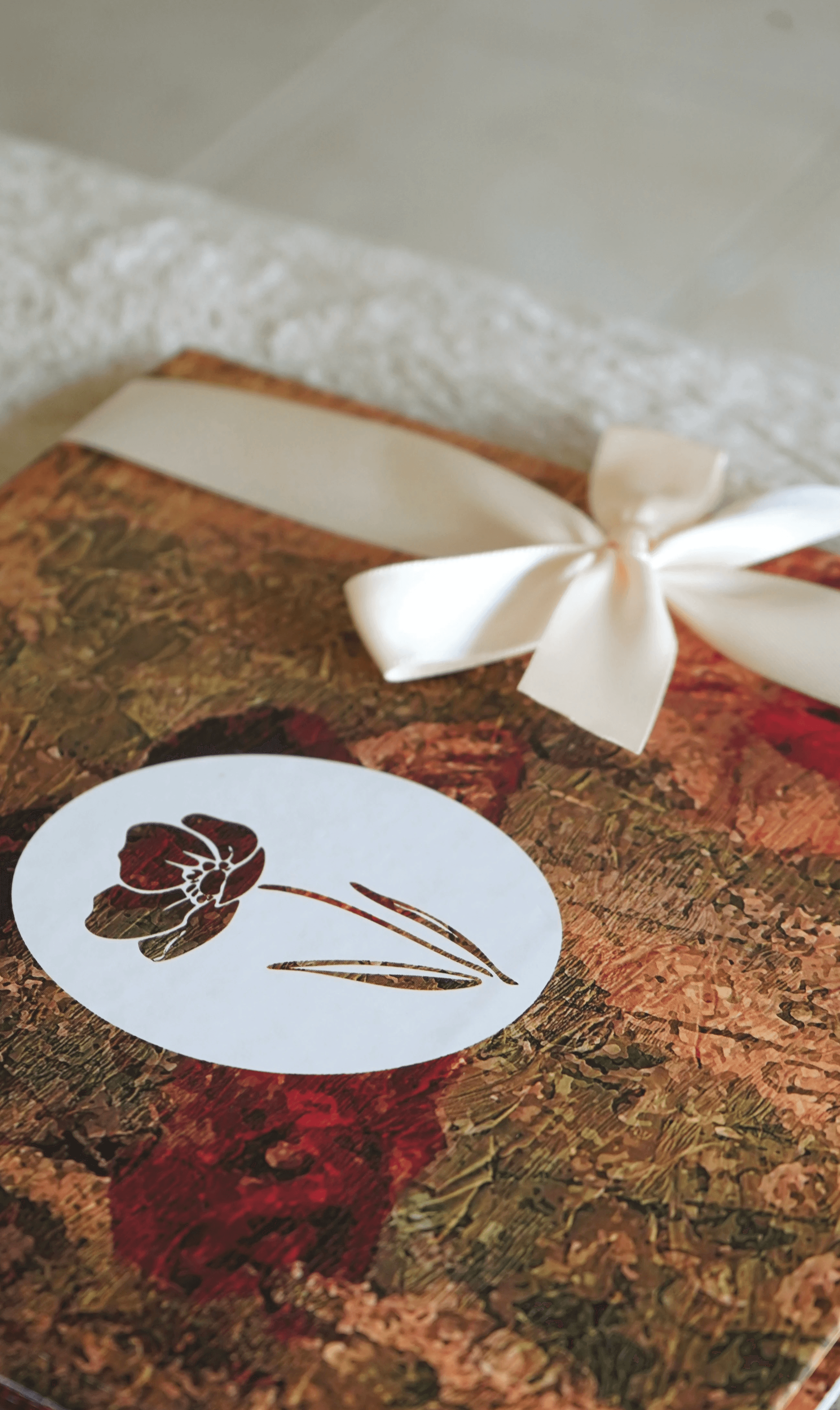 Stylish high-top sneakers featuring a combination of brown, cream, and navy blue leather details, worn with dark rolled-up jeans on a rustic wooden floor.