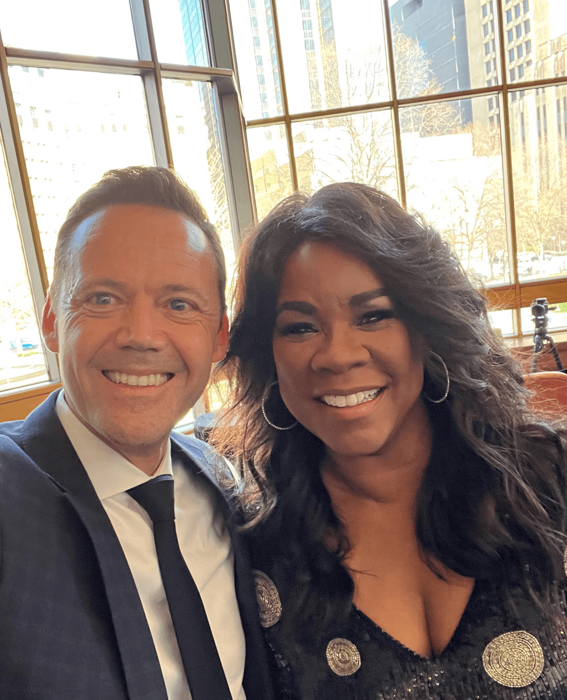 A beautiful black woman and a white man smile into the camera before a performance.