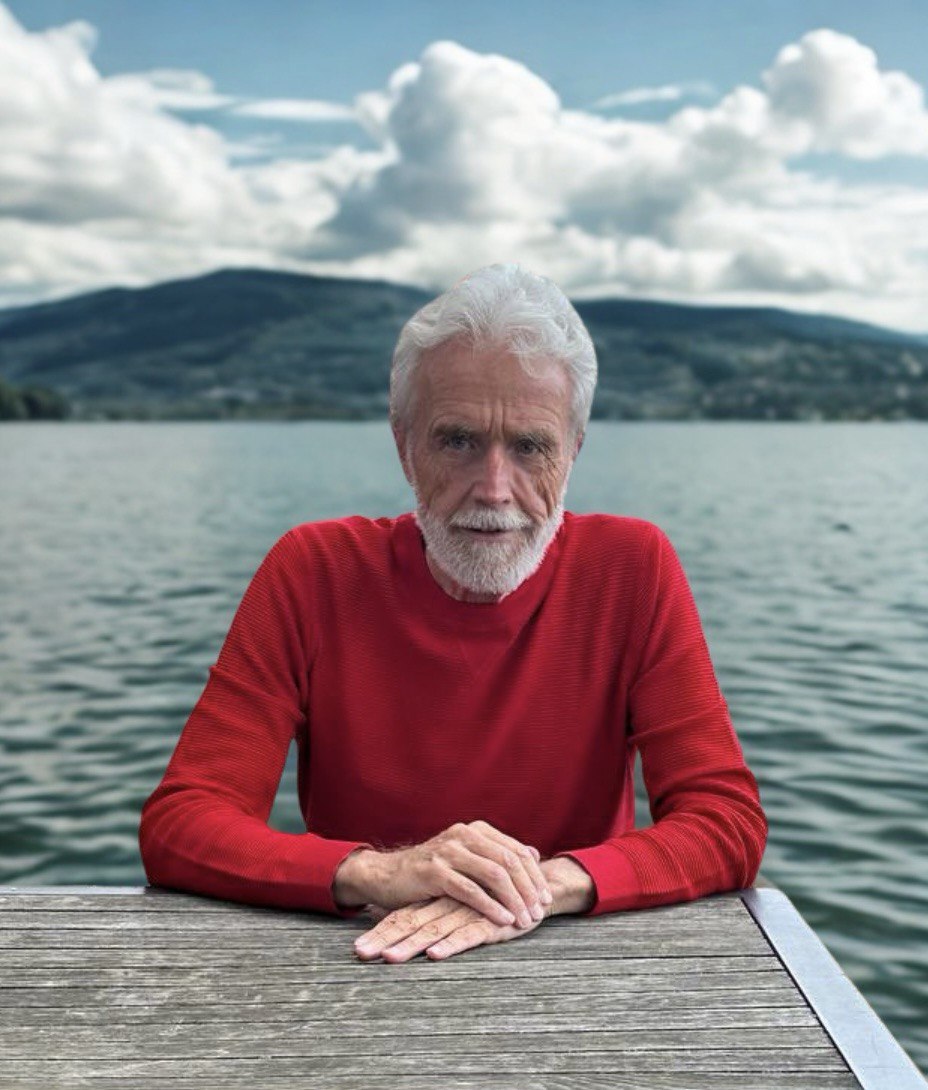 Johannes Nawroth in Rotem Pullover sitzend vor dem Bodensee