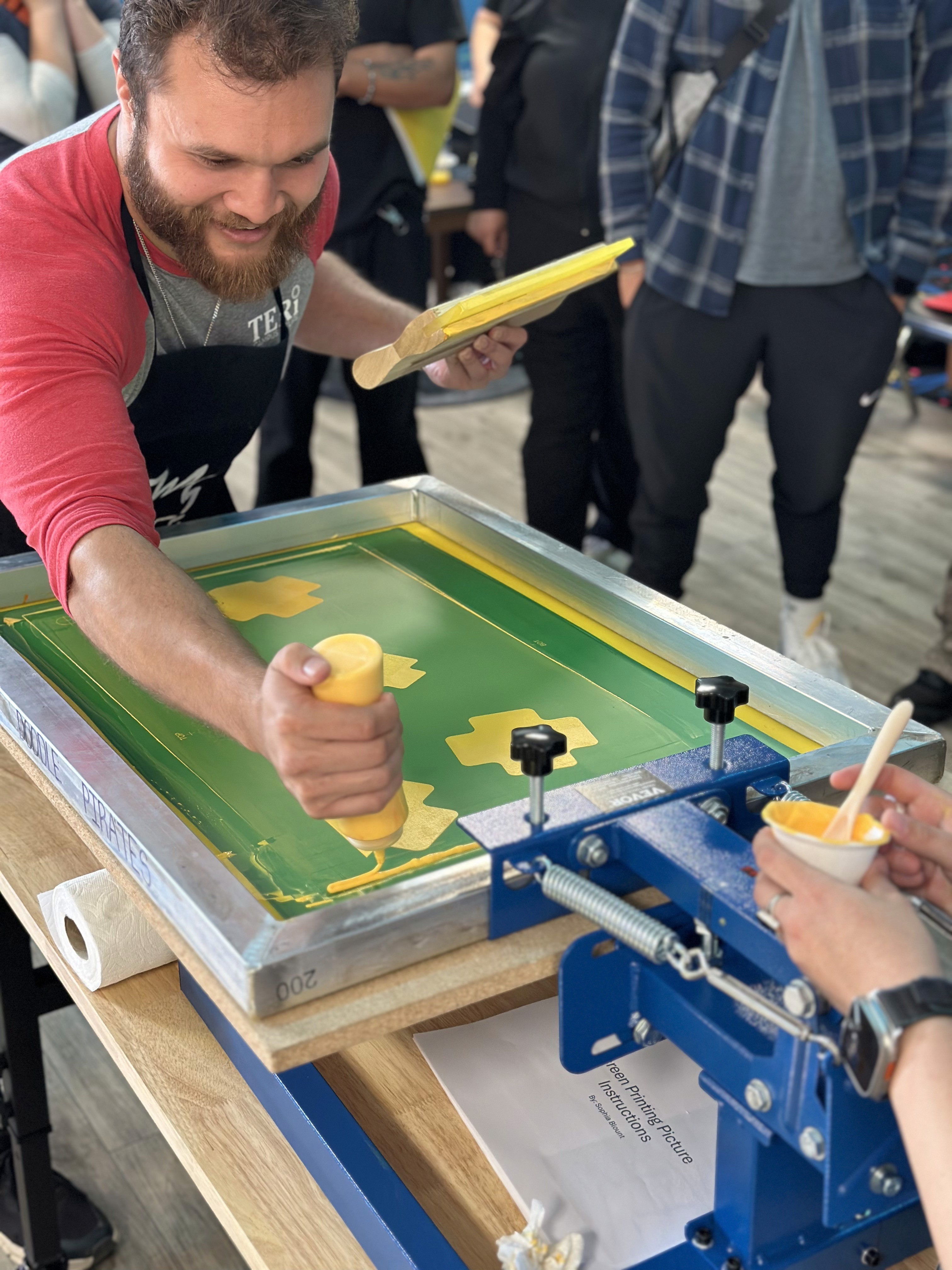 Applying yellow ink to a screen-printing screen at the press