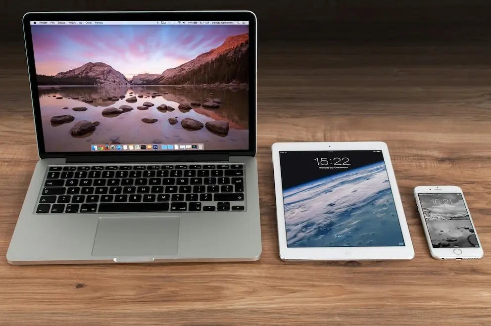 image of a macbook pro, ipad, iphone on a desk