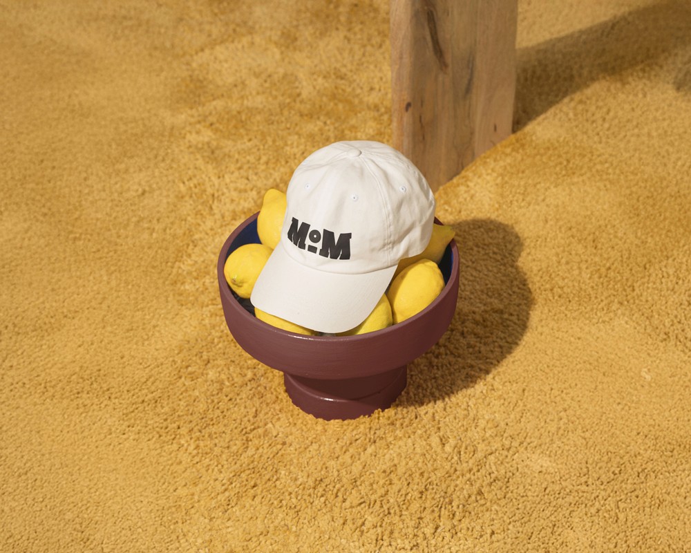 White baseball cap with Mat & Malt embroidered logo resting on a warm terracotta surface, used as project thumbnail for OUF Studio's branding case study.