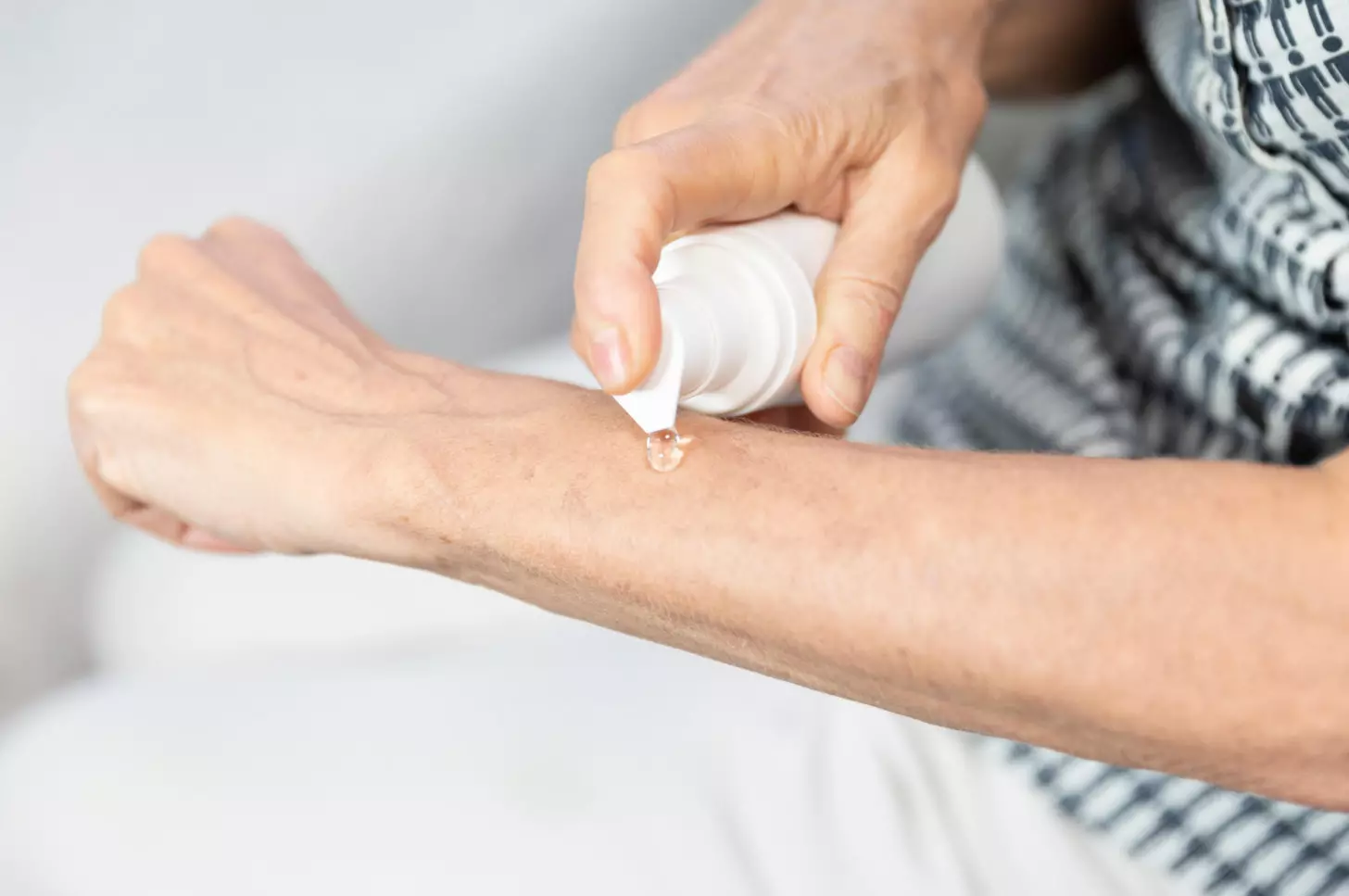 A person applying a cream on their arm.