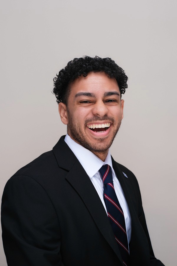 Corporate headshot of a smiling man in a suit and tie