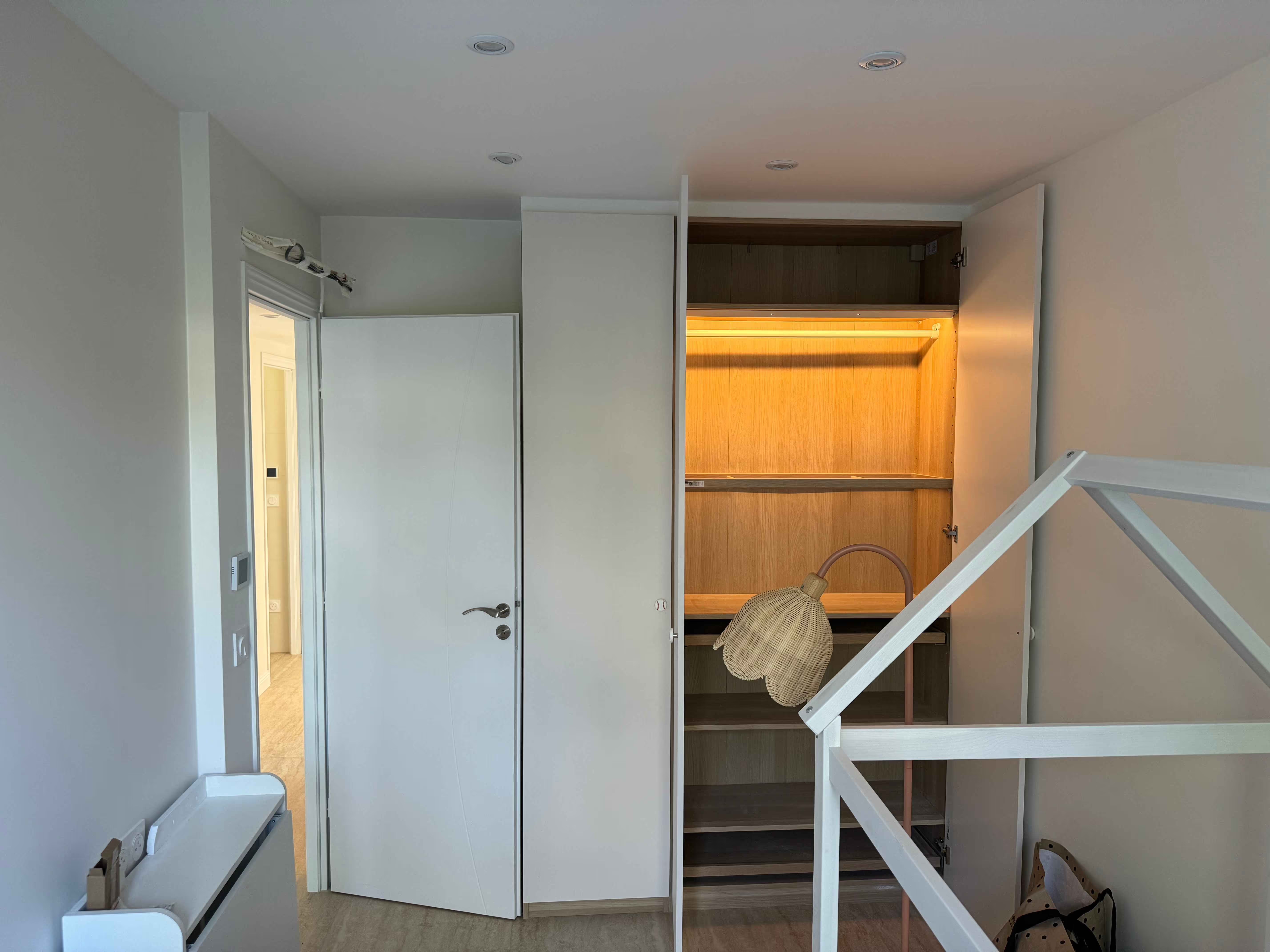 Perspective de la chambre à coucher vers le dressing, montrant une circulation fluide et épurée.