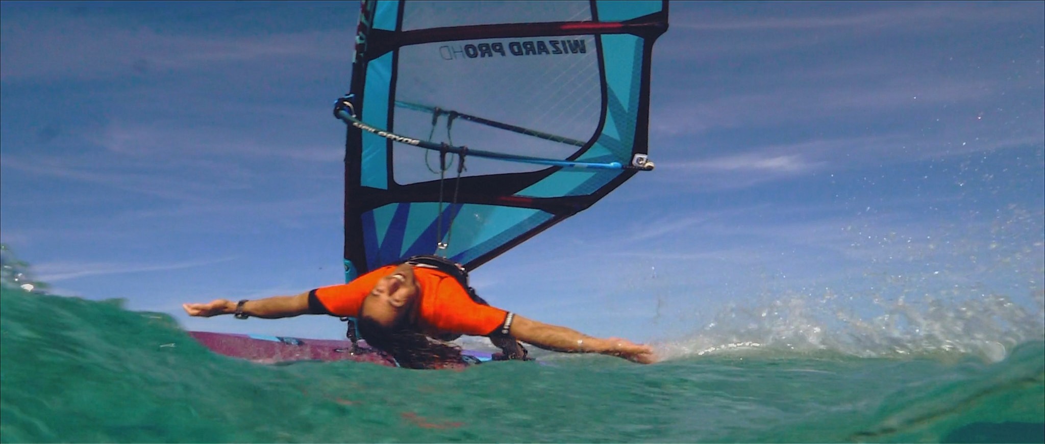 windsurfer spreading arms looking at camera smiling