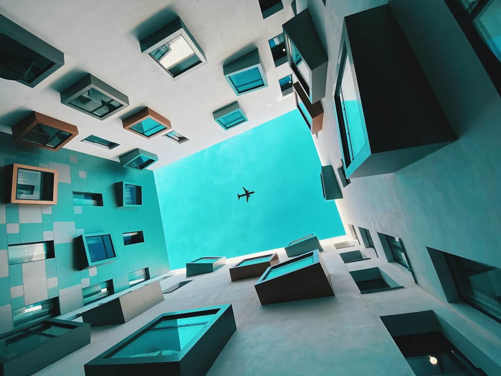 An airplane flew across the sky in the courtyard of the building.