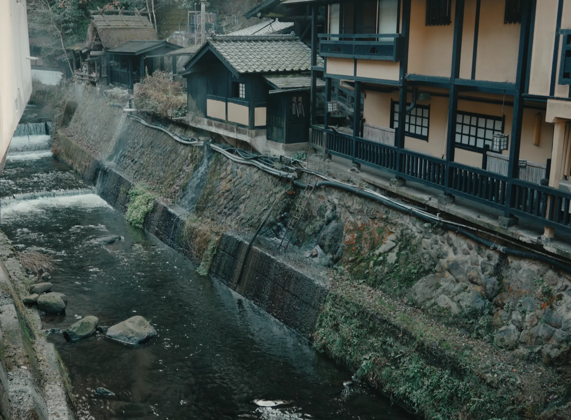 The river running in a stone channel below timber inns with overhanging balconies