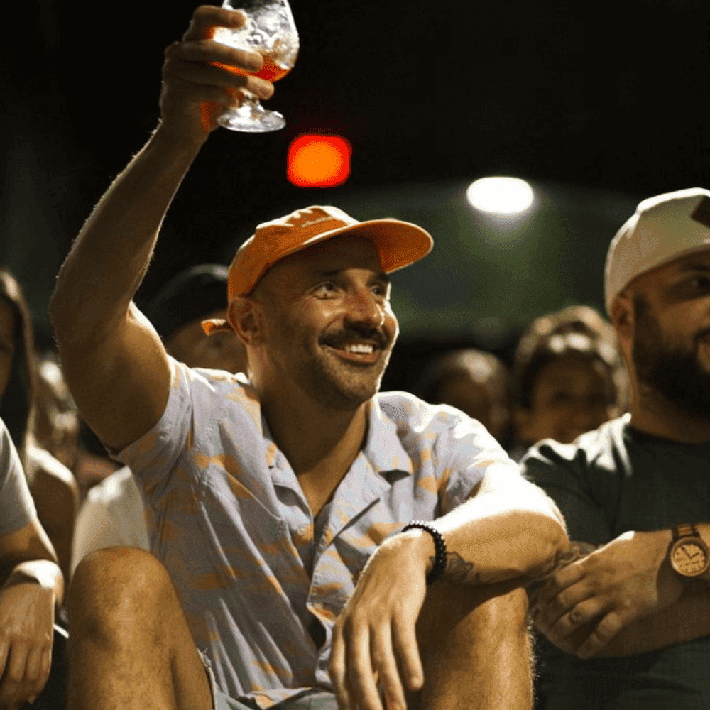 Man raising a toast at a St Pete Standup show