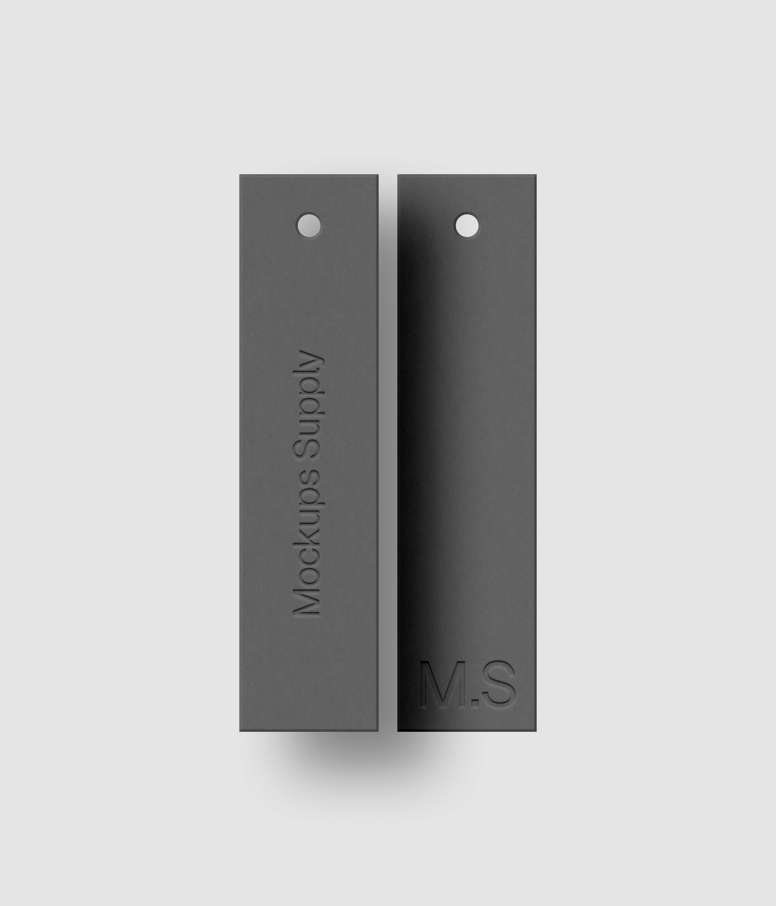 Two gray 1x4 vertical clothing label mockup on white background with natural shadow depth and debossed text effect for Photoshop download psd