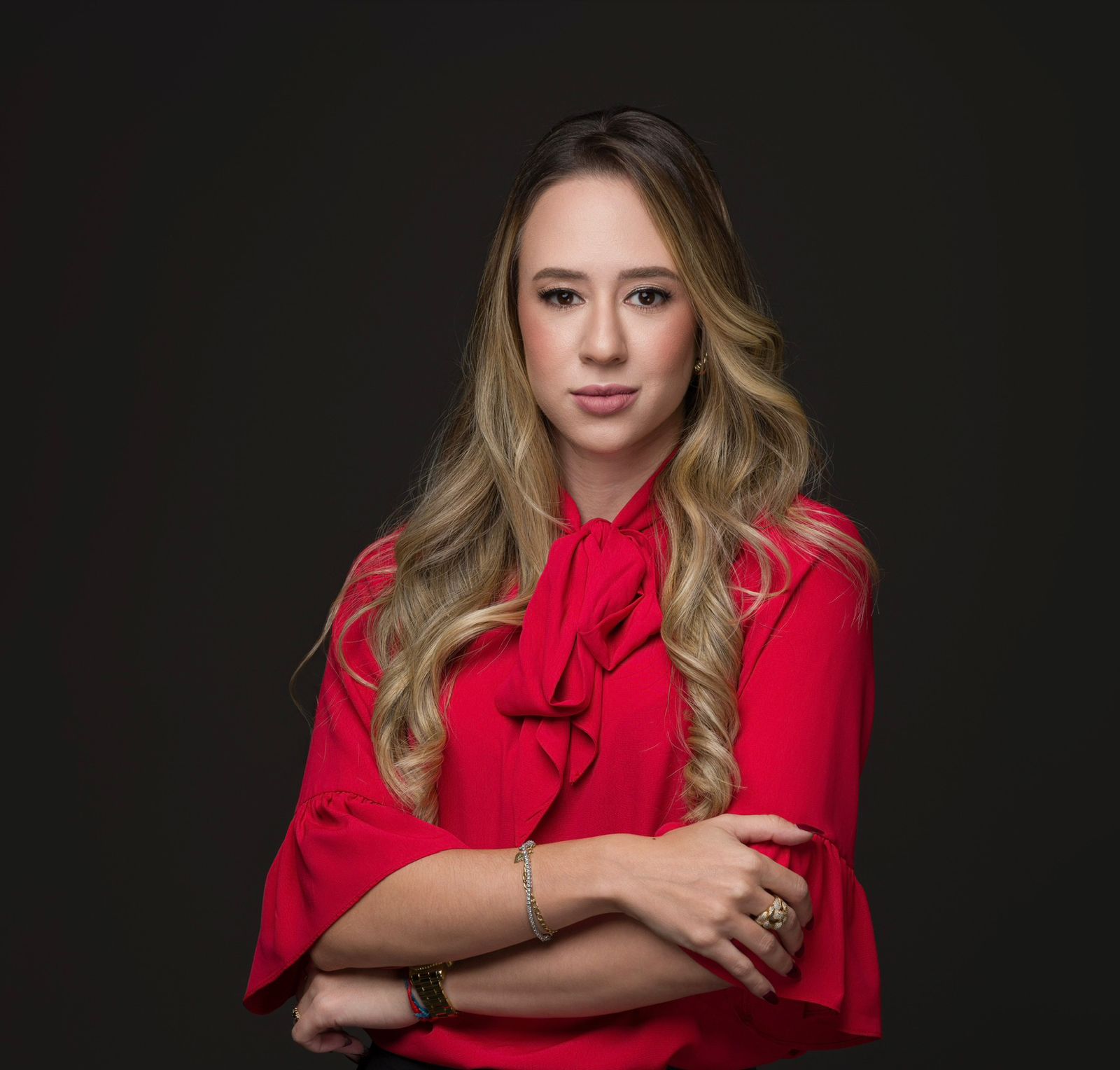 A woman in a business suit standing with her arms crossed