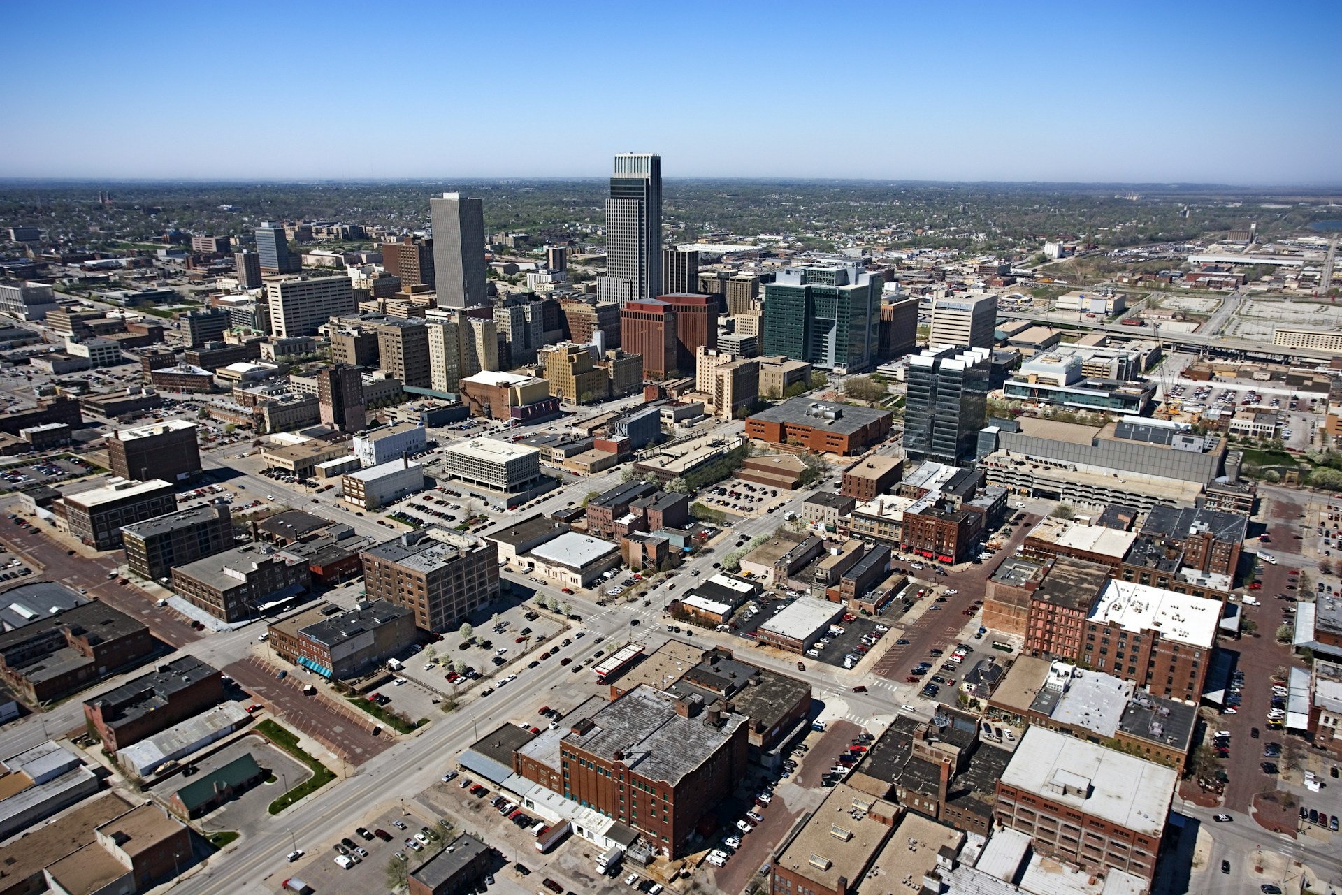 Aerial view of a flat downtown grid with mid-rise office buildings under clear sky.
