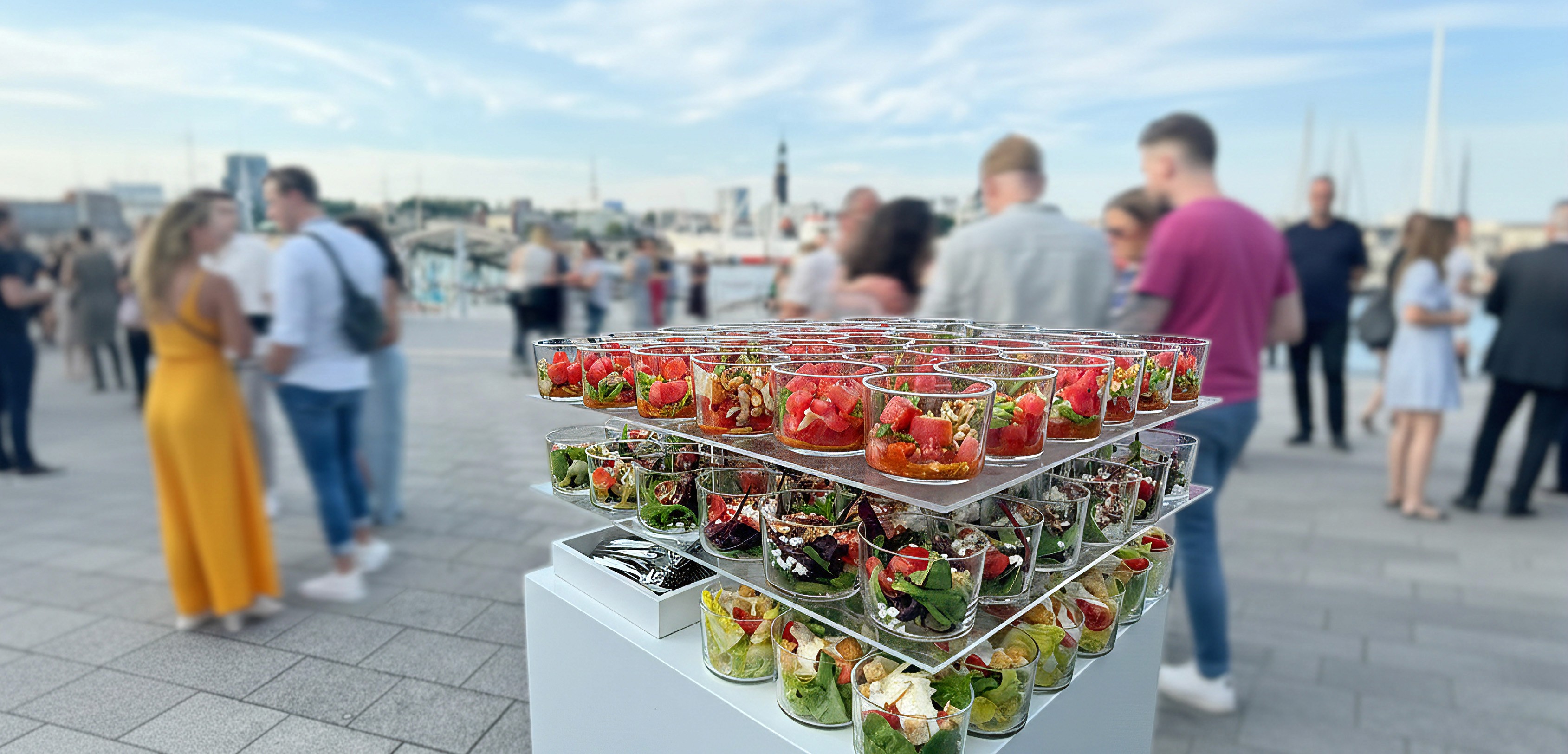 Outdoor-Event-Catering mit Fingerfood-Buffet und Gästen vor Hamburger Skyline