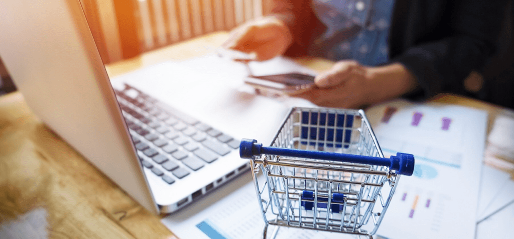 Shopping cart beside the laptop