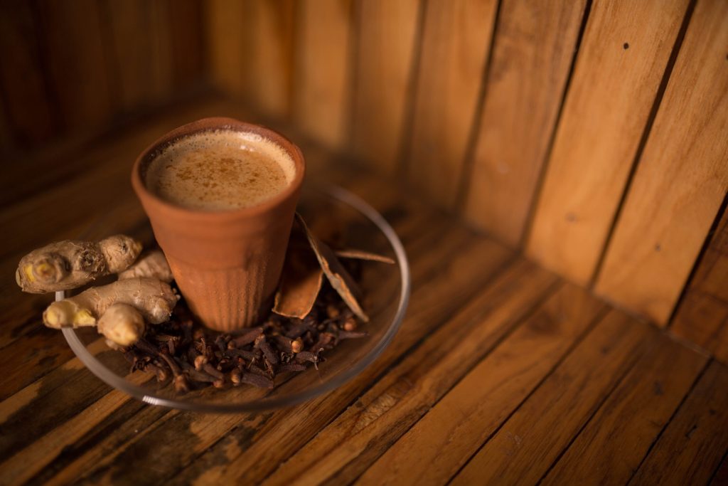 A beautiful, tropical poolside breakfast setup on a sunny morning, featuring a plate with two fried eggs over hash, a bowl of diced tomatoes, orange juice, coffee, toast, and a vase of white lilies.