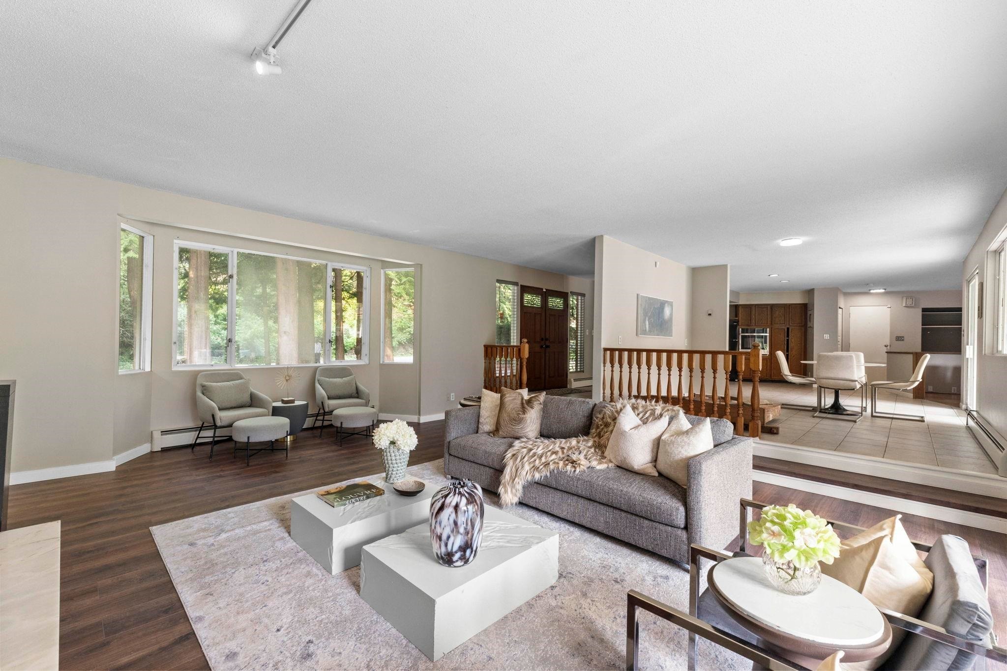 A spacious living room with modern furniture, large windows, and a cozy atmosphere.