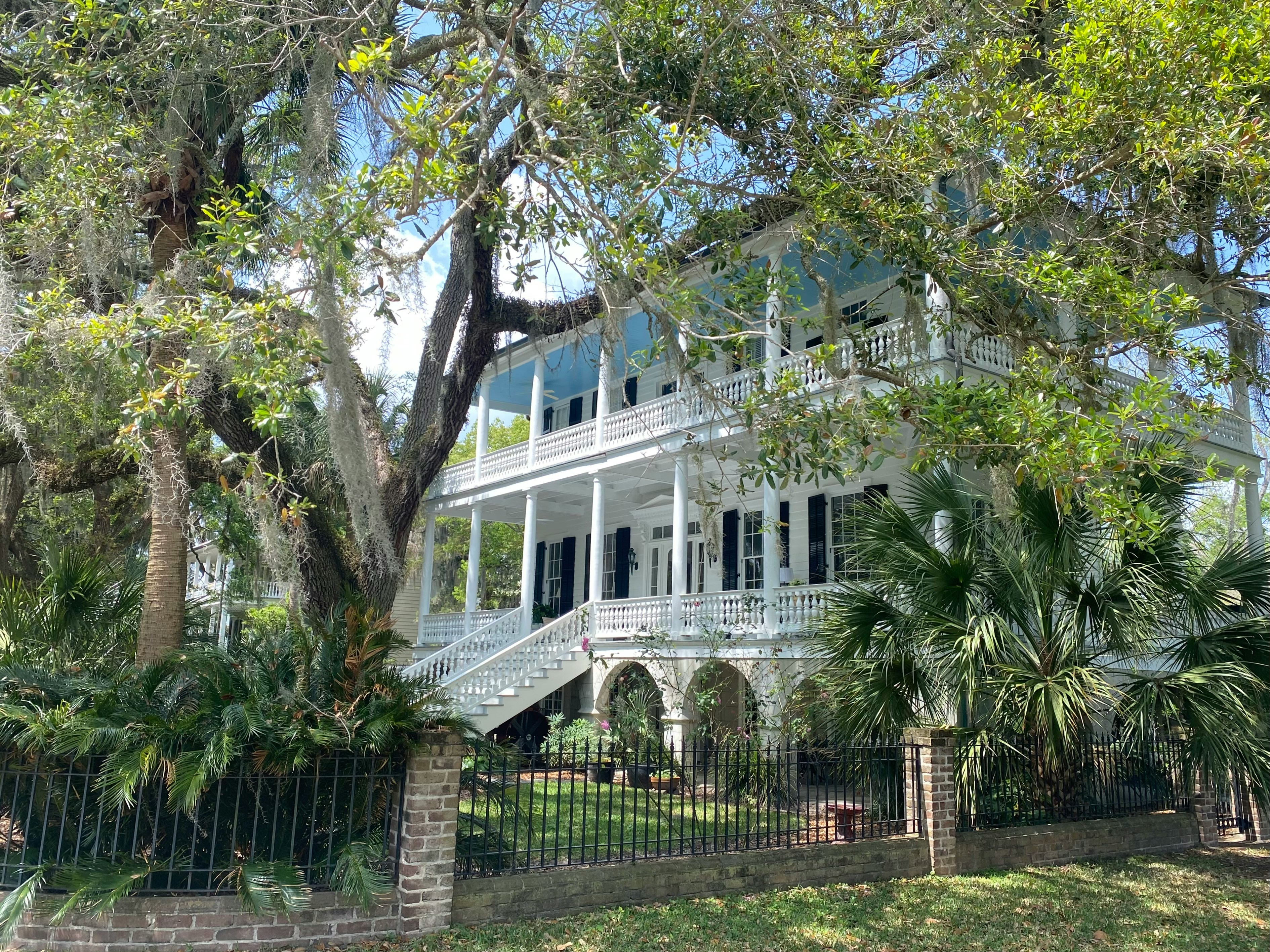 a large white house with a large tree in front of it