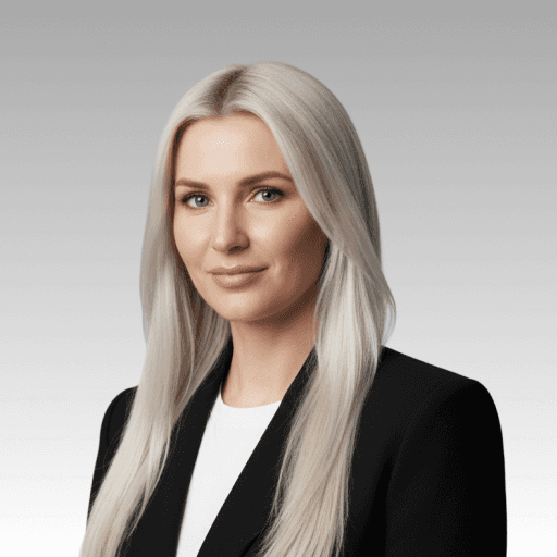 Blonde woman in a black blazer and white shirt, looking directly at the camera with a neutral expression.