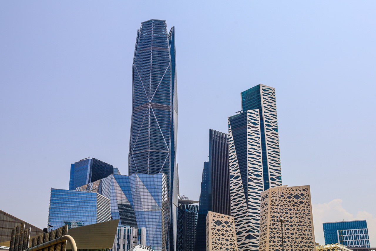 The striking architecture of Riyadh's King Abdullah Financial District with tall skyscrapers, showcasing the modern skyline. The image emphasizes SAA Law as 'Your Proactive Legal Partner' set against a backdrop of innovation and progress.