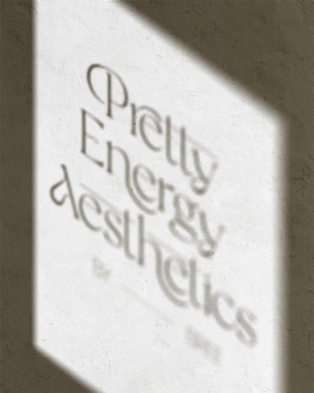Pretty Energy Aesthetics logo in the shadow of a window on a white wall