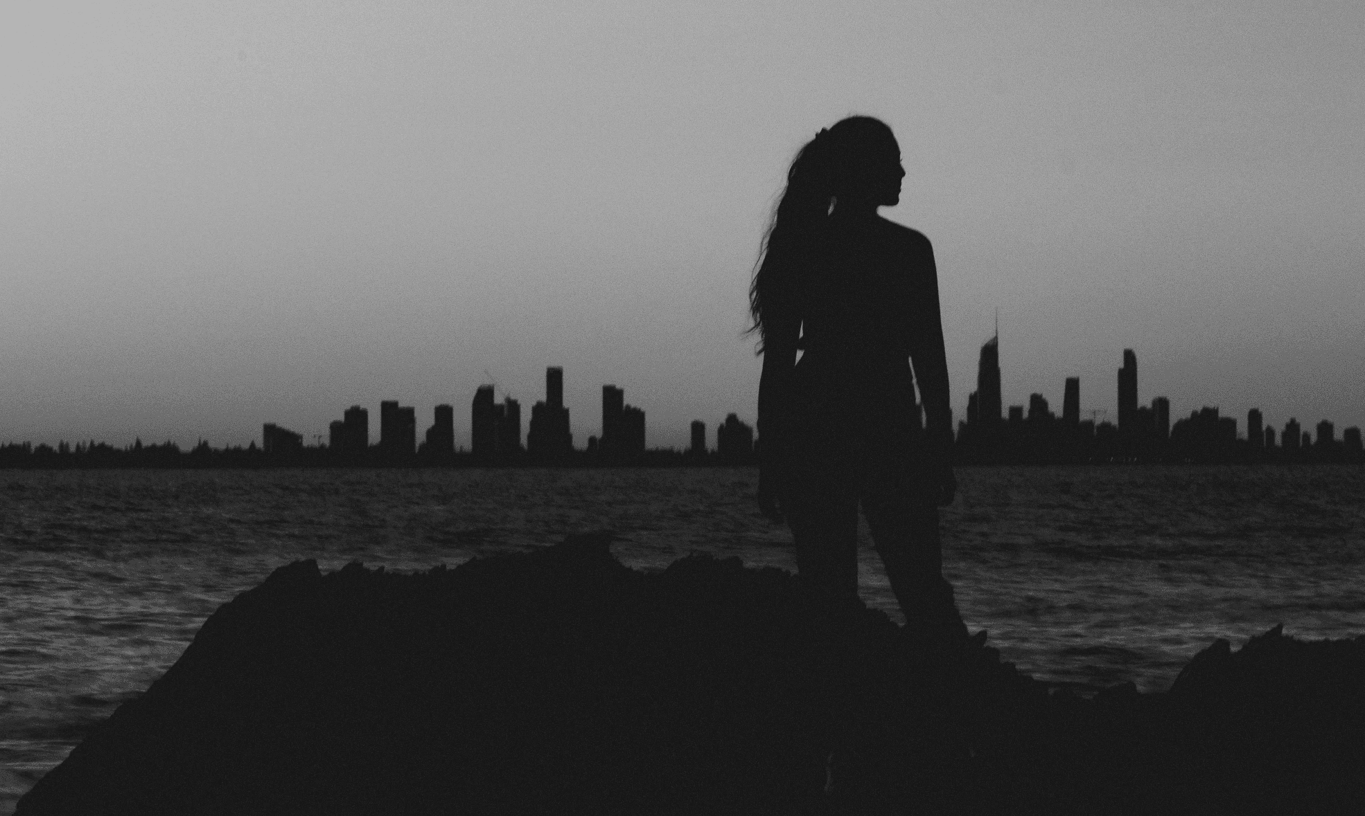 silhouette of woman near shoreline
