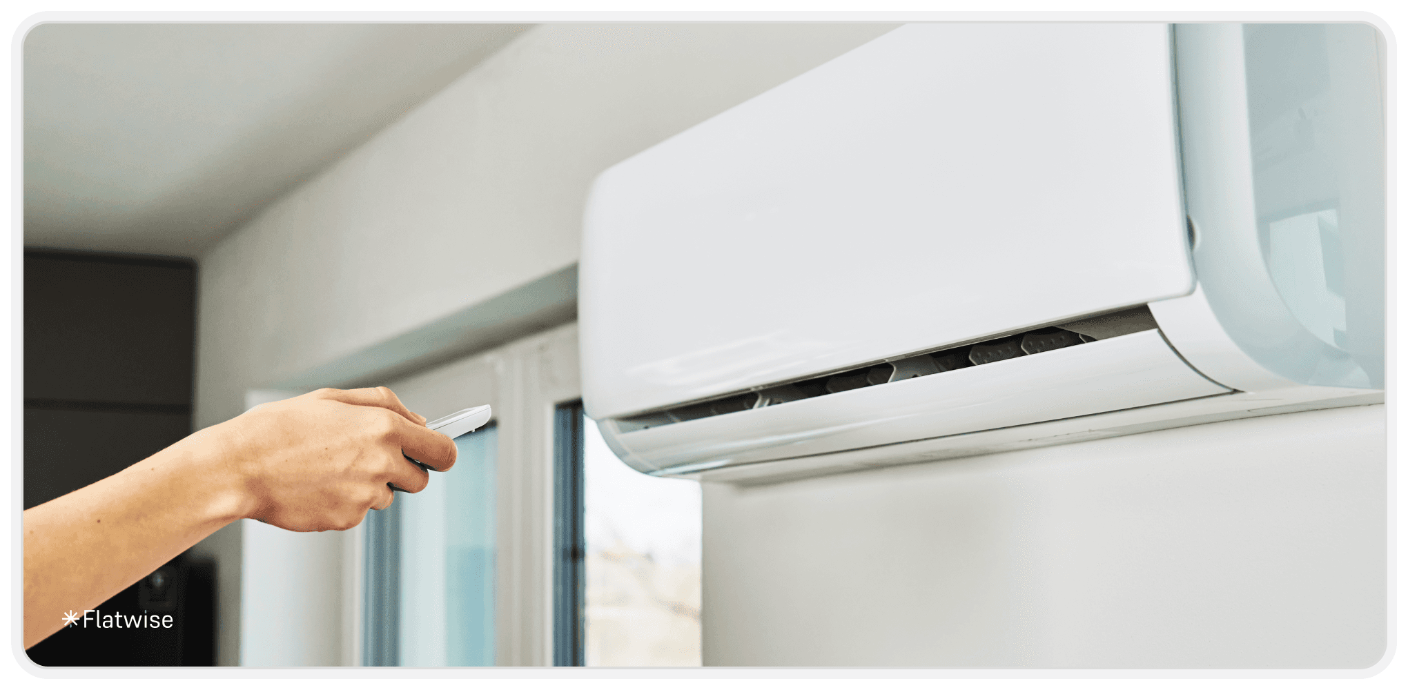 Eine Hand, die die Temperatur manuell an der Klimaanlage einstellt.