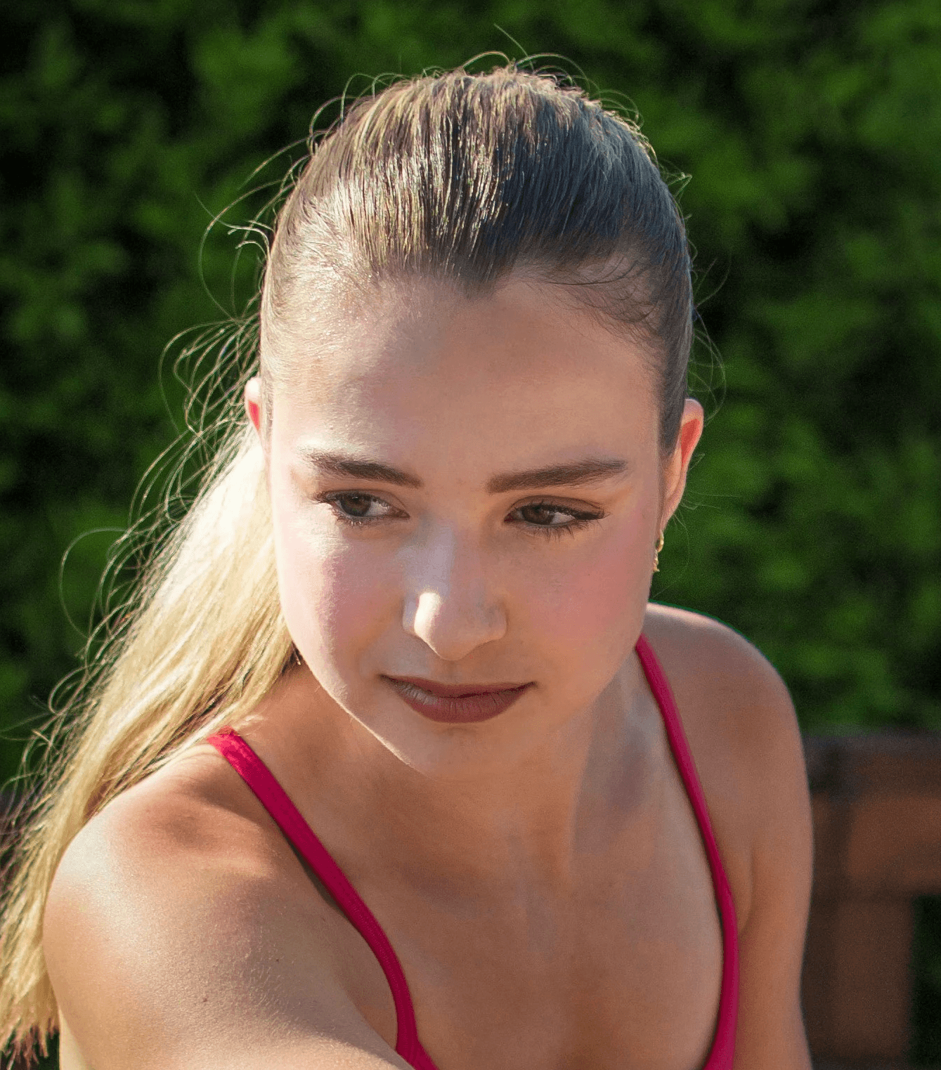 Young woman stretching her leg outdoors on a wooden deck.
