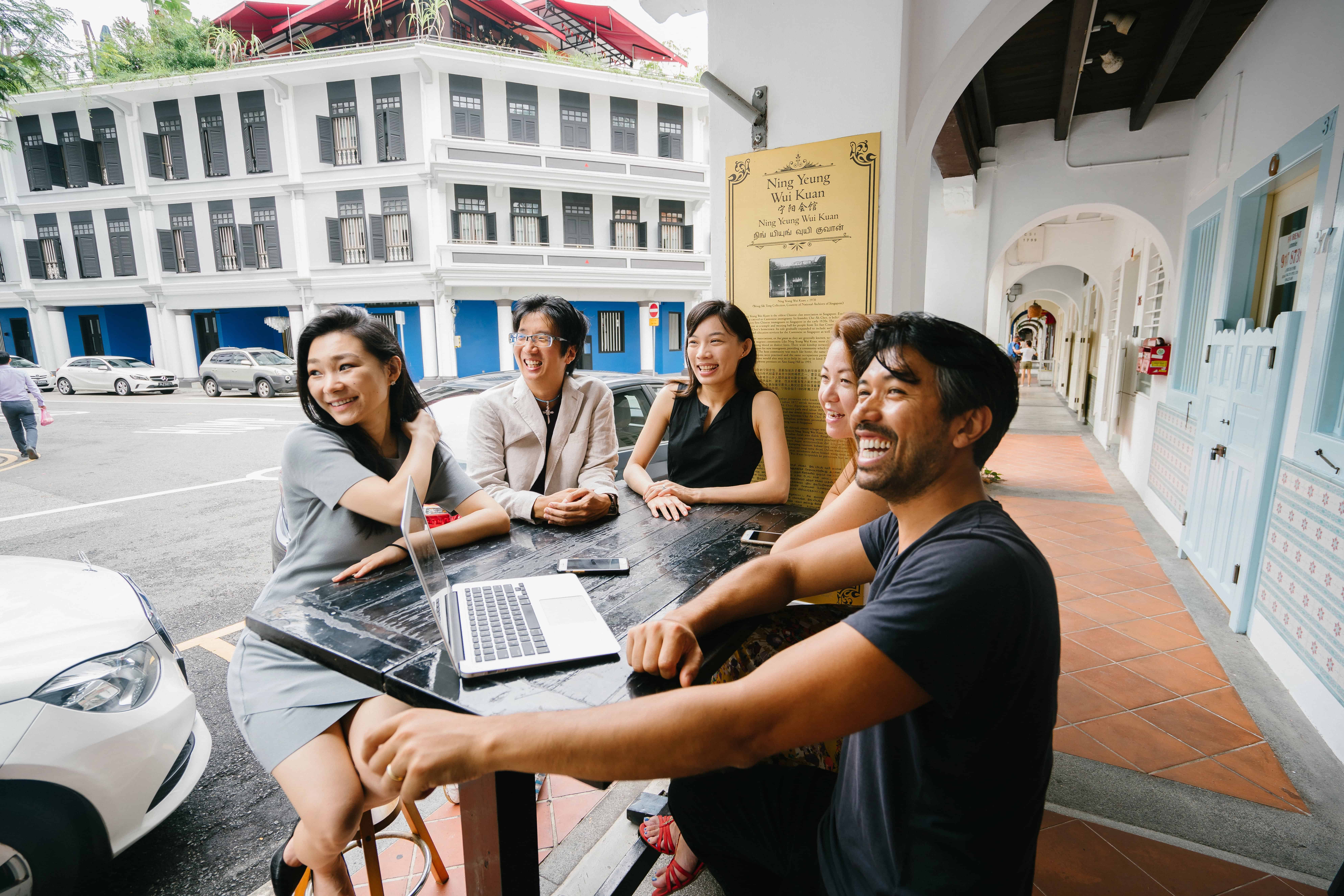 Diverse group of Singaporean workers socialising after finishing a work meeting