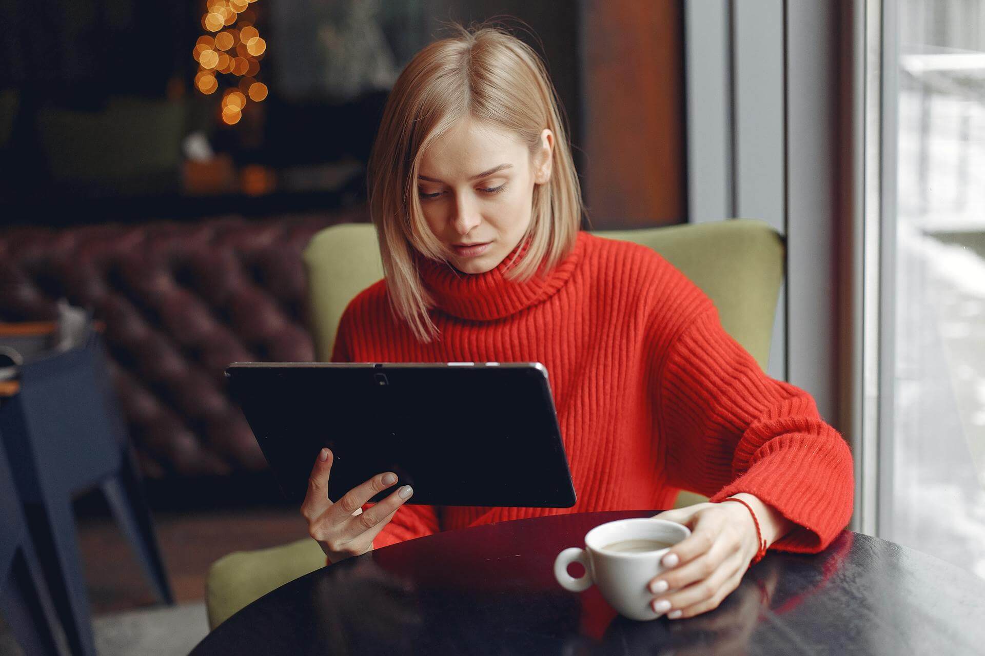 a women wearing red shirt and using a tablet