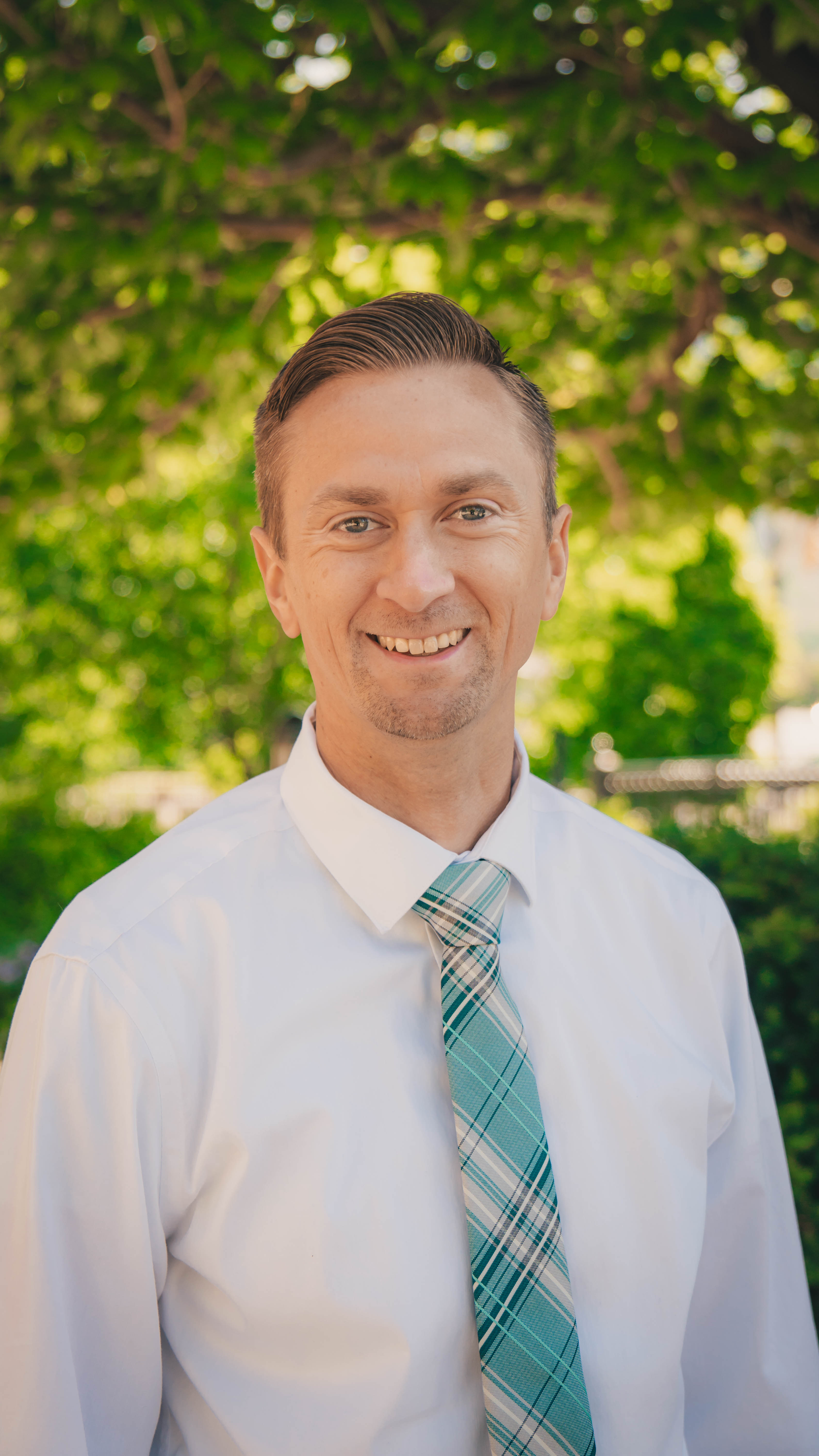 Professional headshot of a licensed counselor, smiling outdoors.