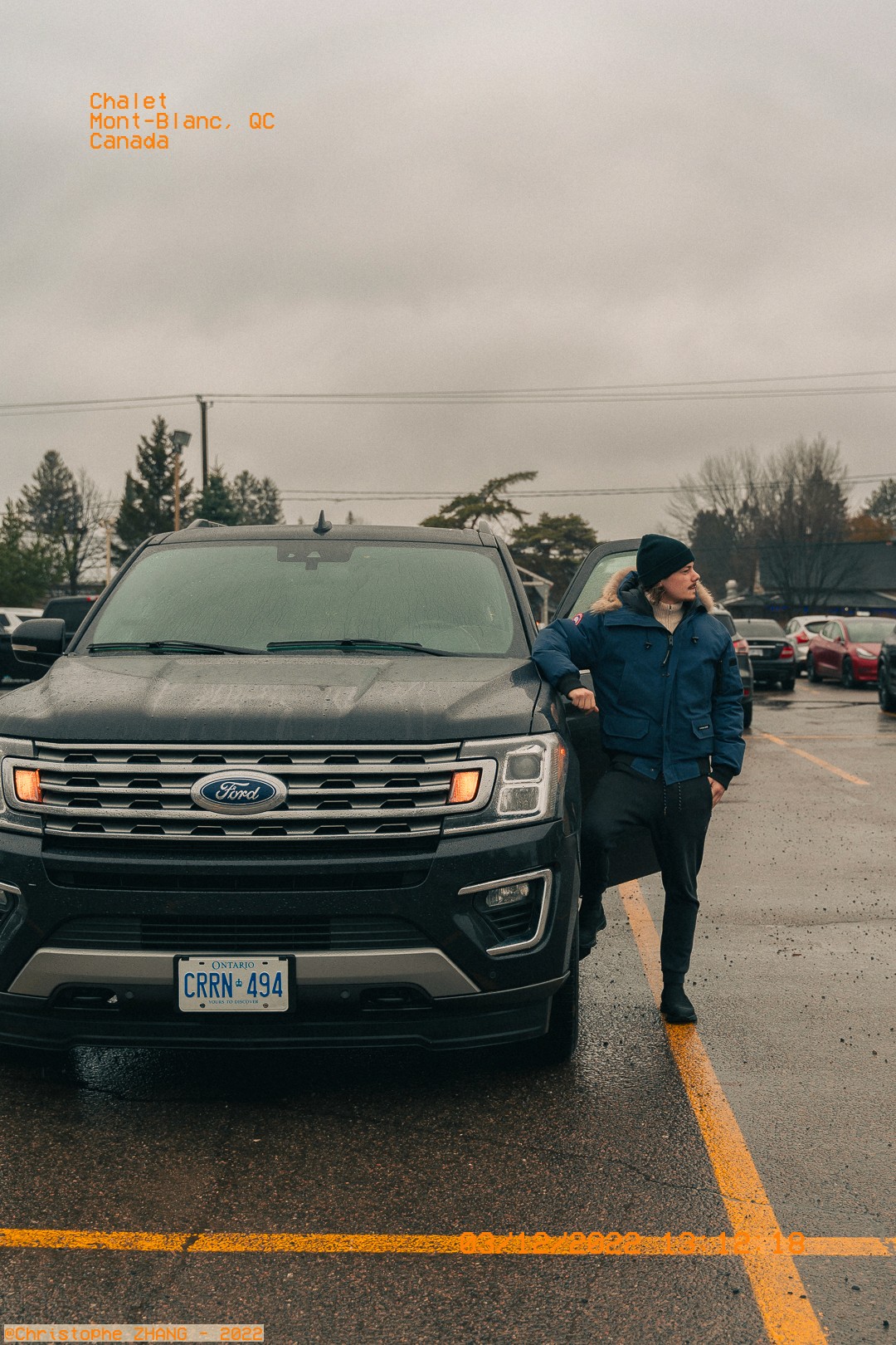 Portrait lifestyle appuyé sur SUV sous la pluie, Mont‑Blanc, Québec.