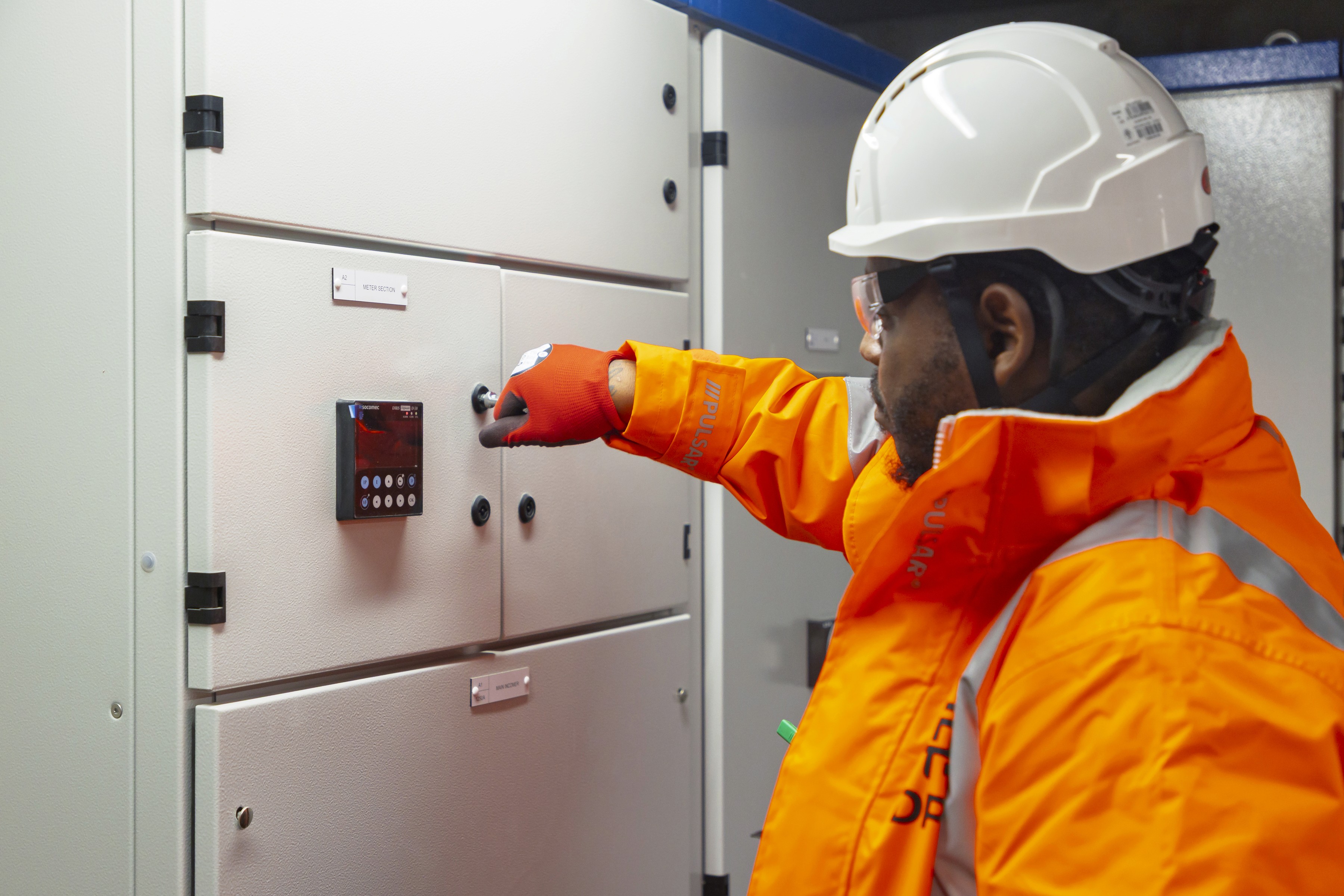 Modern glass building with illuminated trees and a view of city skyscrapers