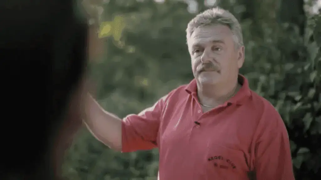 Portret mężczyzny przy blacie na ktorym stoją zabawkowe samochody