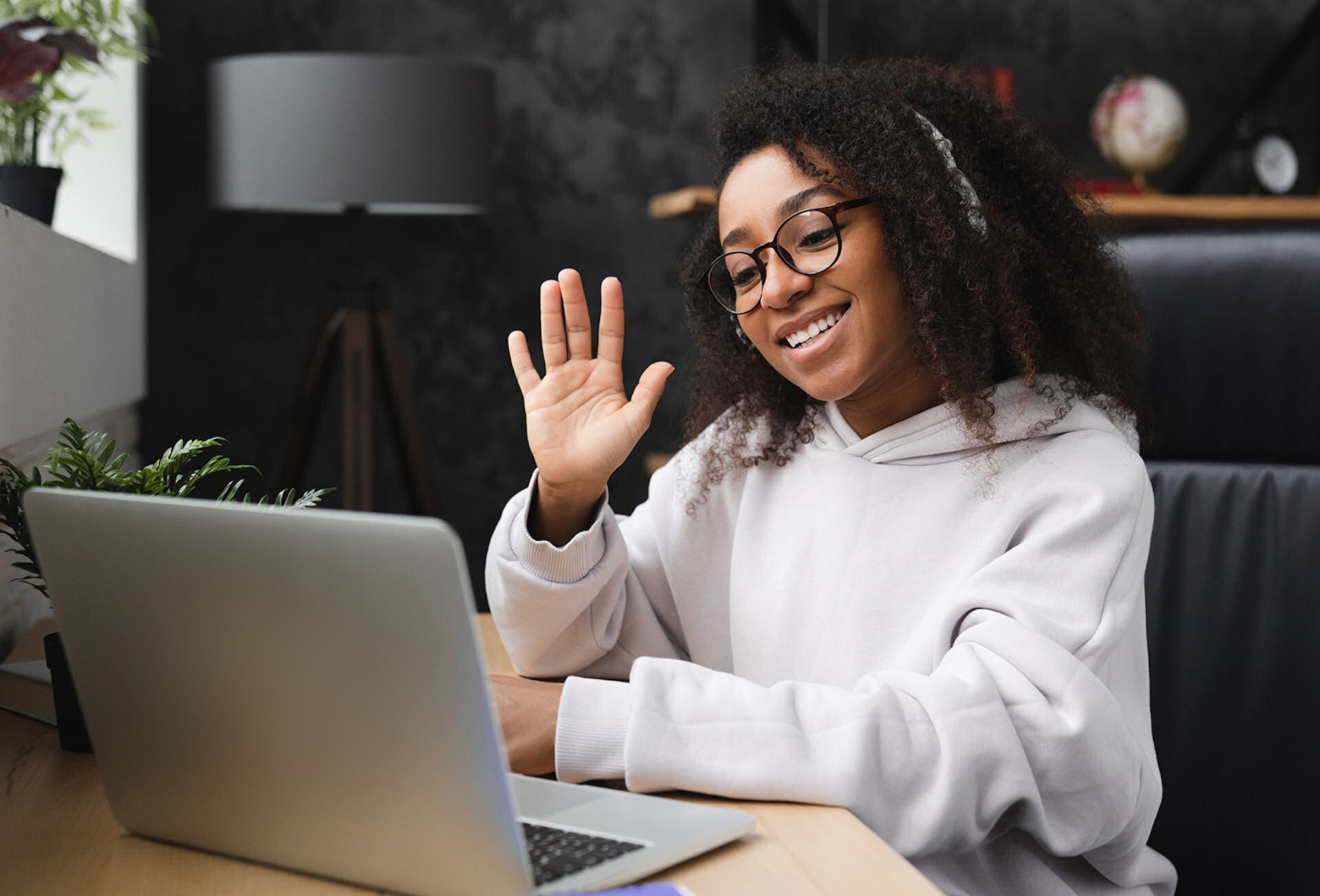 person writing on brown wooden table near white ceramic mug