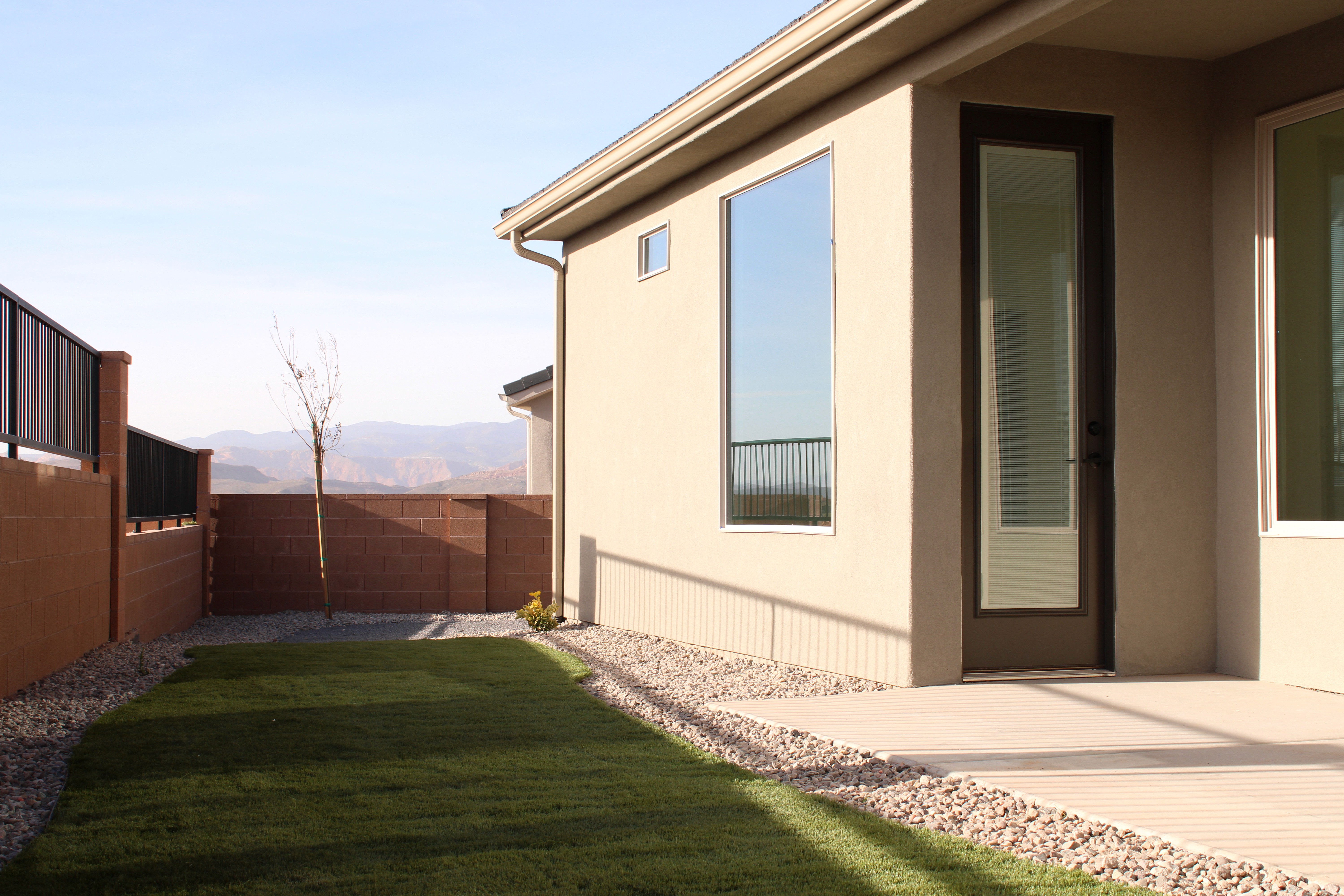 Rear exterior of the Golden Hour home in Hurricane, Utah featuring large windows and backyard space.